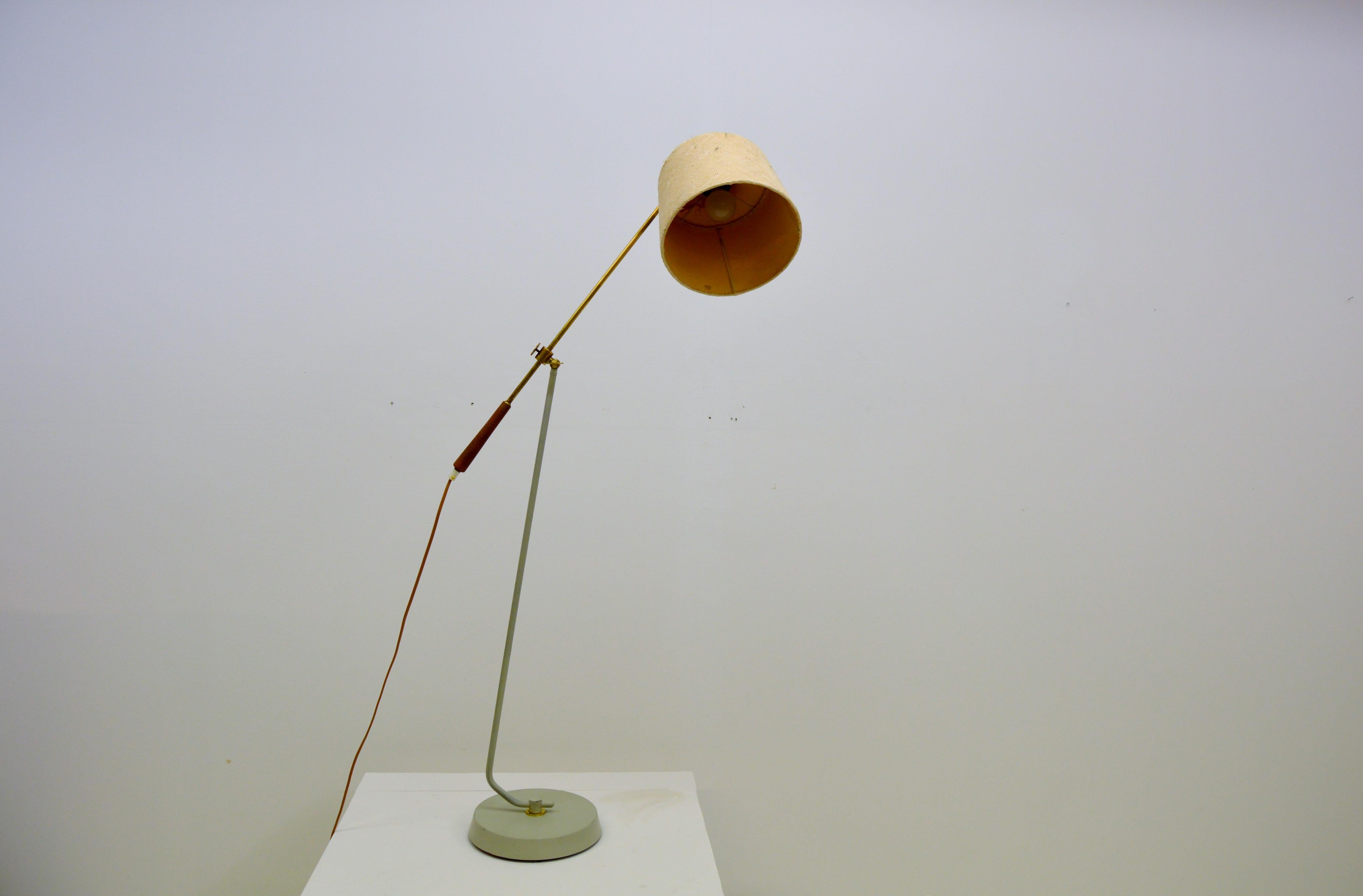 This lamp was made by Göteborgs Armaturhantverk during the 1950s or 1960s and is very desirable and unusual.
Adjustable height and movable arm length. Height 110-140 centimeters.

Brass and teak details. White-grey laquered metal with some color