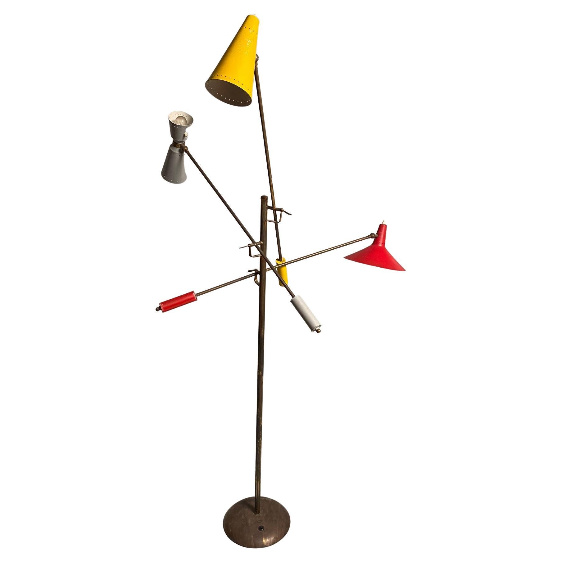 Rare and monumental Stilnovo floor lamp in brass, consisting of three adjustable arms. The lamp is placed in a context of experimental design typical of Mid-Century Italian design, very reminiscent of the famous Triennale lamp by Angelo Lelii, and