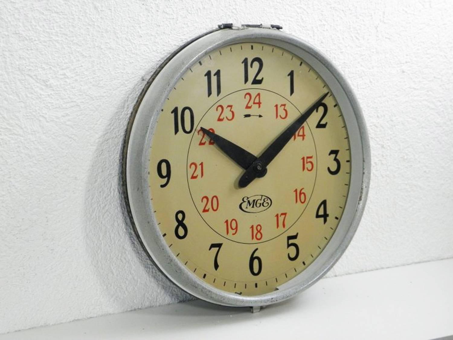 Steel painted with glass front made in Germany in the 1930s by company Mix & Genest which was a part of AEG concern (EMGE-Union) from 1926.
Formerly a slave clock, it is now fitted with a modern quartz movement with a battery. 
Delivery time about