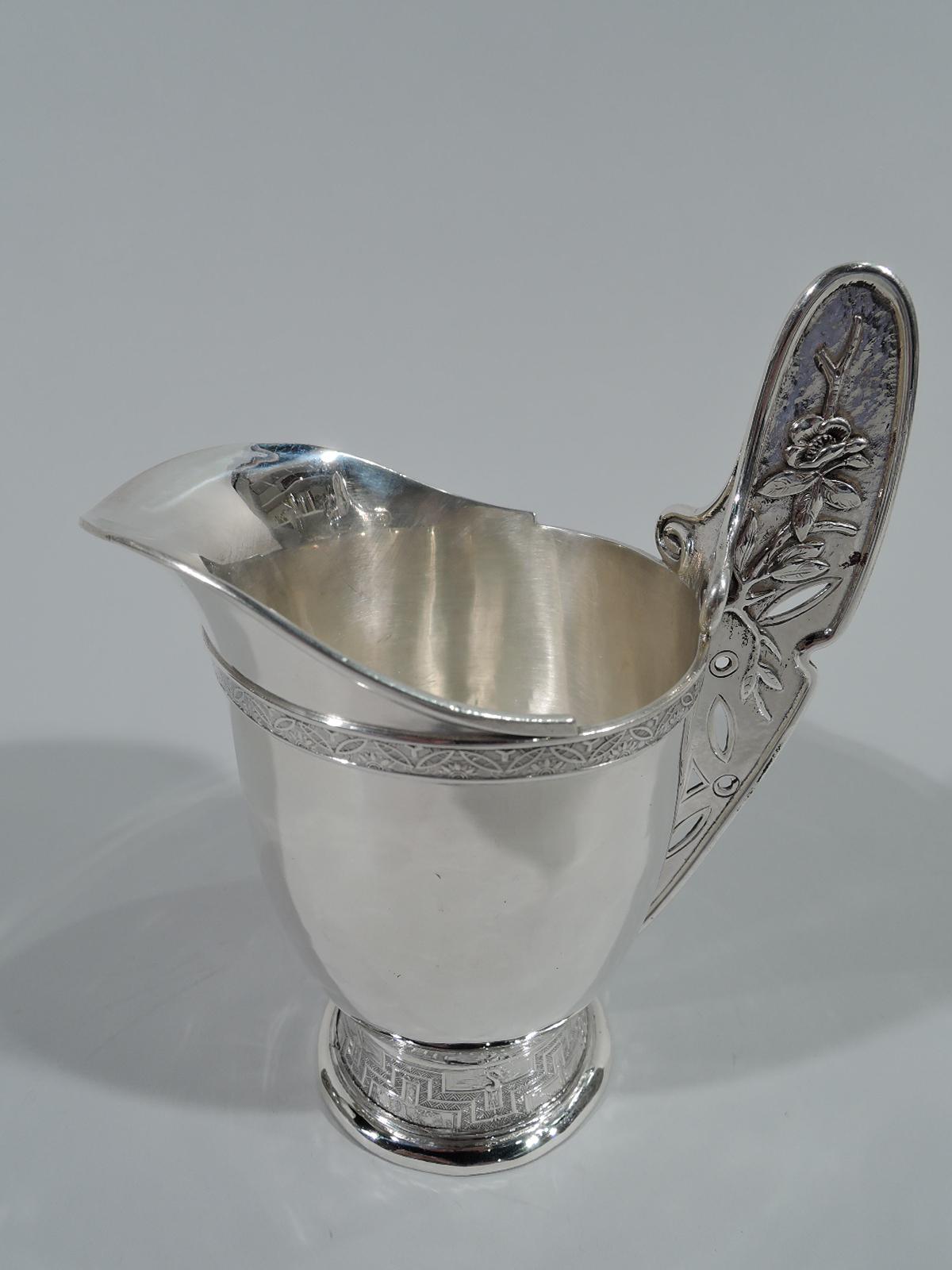 Japonesque sterling silver creamer and sugar. Made by Tiffany & Co. in New York. Each: Curved and tapering bowl on raised and spread foot decorated with fretwork, cranes, and blossoming branches. Flat and tall fan-form handles with volute scrolls