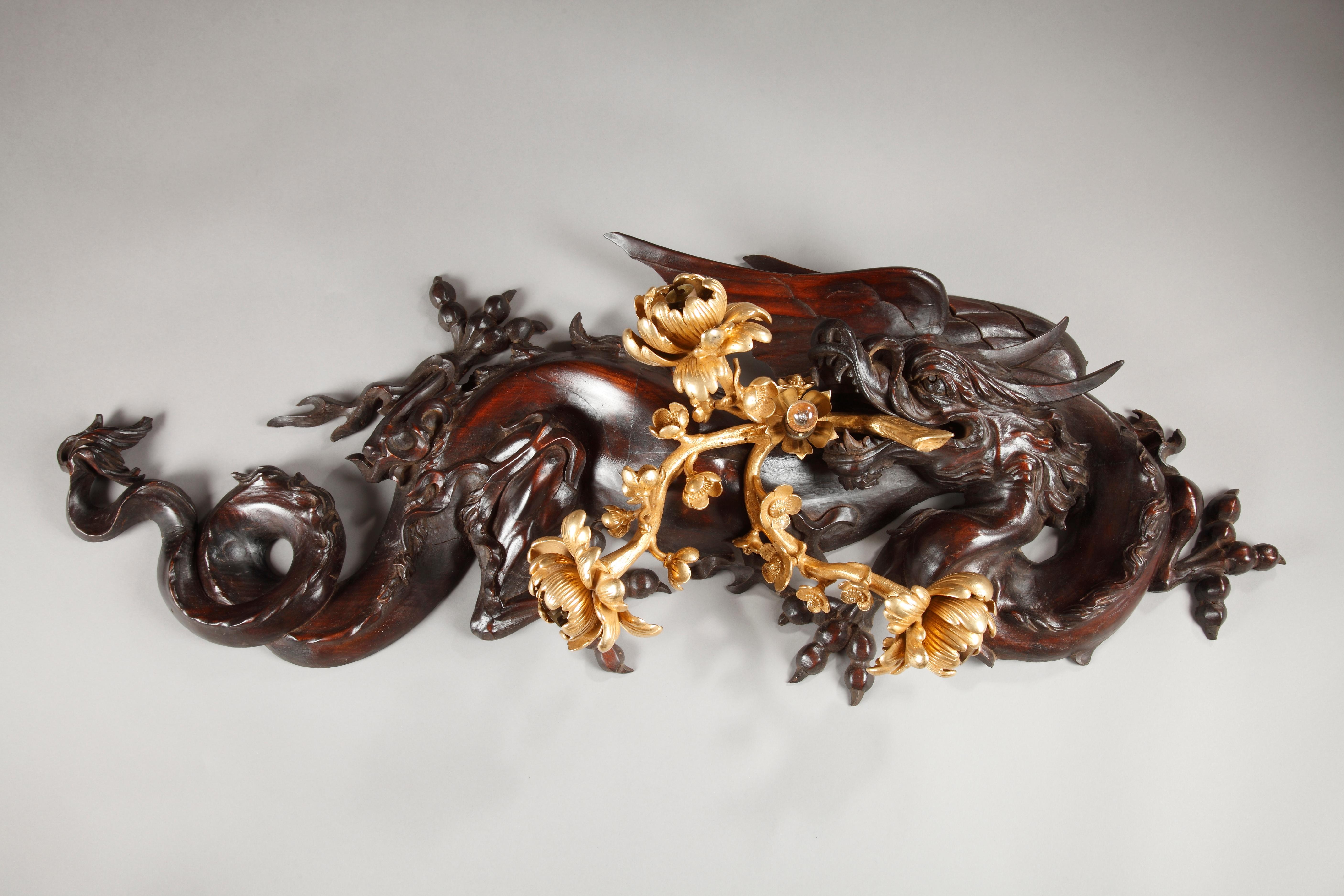 A large Japanese style four lights sconce attributed to G. Viardot, in shape of a dragon made in carved tinted wood, holding in its mouth a Japanese blossoming cherry tree branch, from which issues four bulb lights.

This wall-light is to be