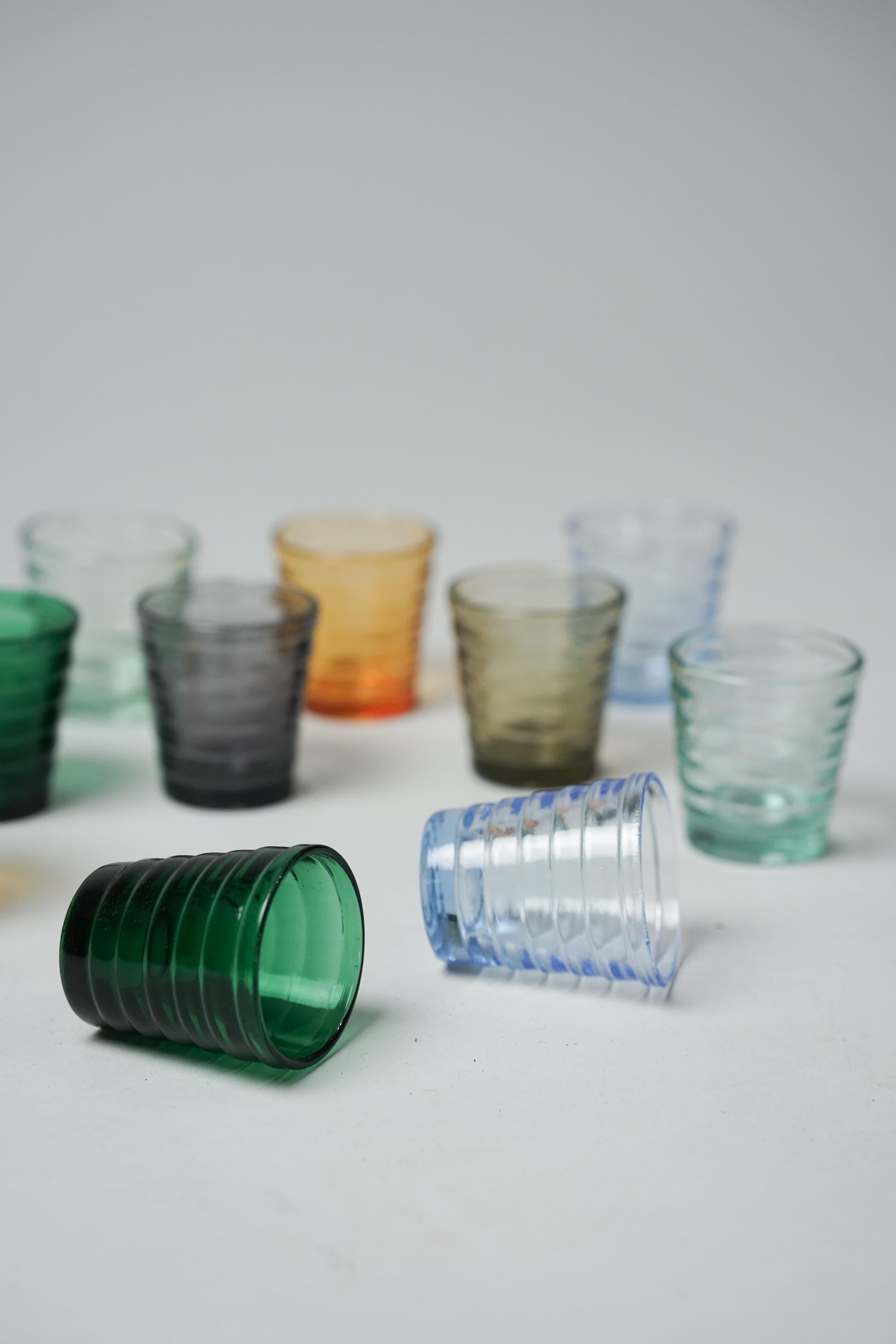 Rare Aino Aalto shot glasses (12 pieces in total), manufactured by Karhula, 1930s. Various different color glasses. Good vintage condition, minor patina consistent with age and use. The shot glasses are sold as a set.

Aino Aalto (1894-1949) was an