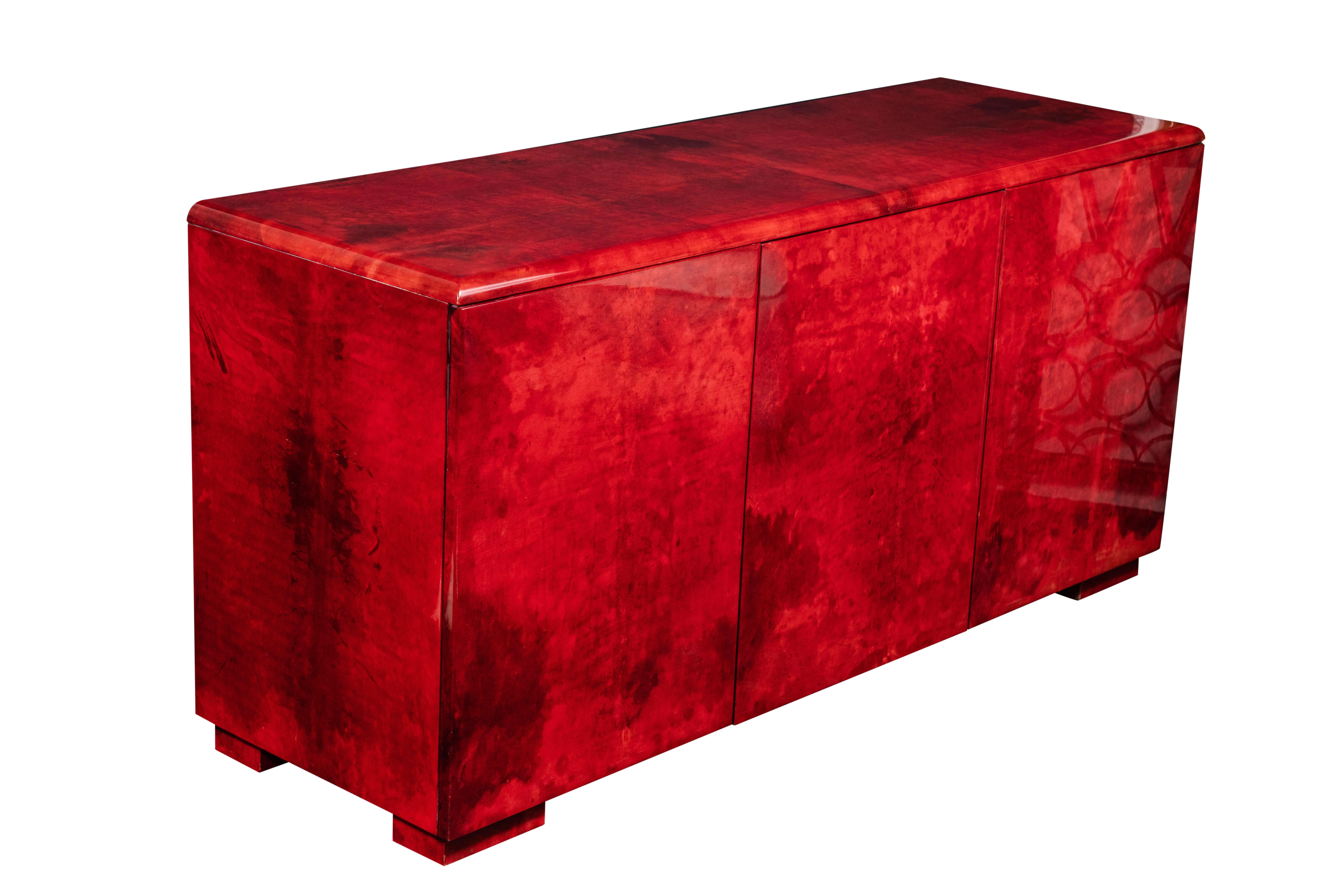 Spectacular sideboard or cabinet in rare ruby colored lacquered goatskin by Aldo Tura, circa early 1970s. The doors open to review blonde maple wood. The sideboard is in excellent vintage condition. This is a statement piece in any room.