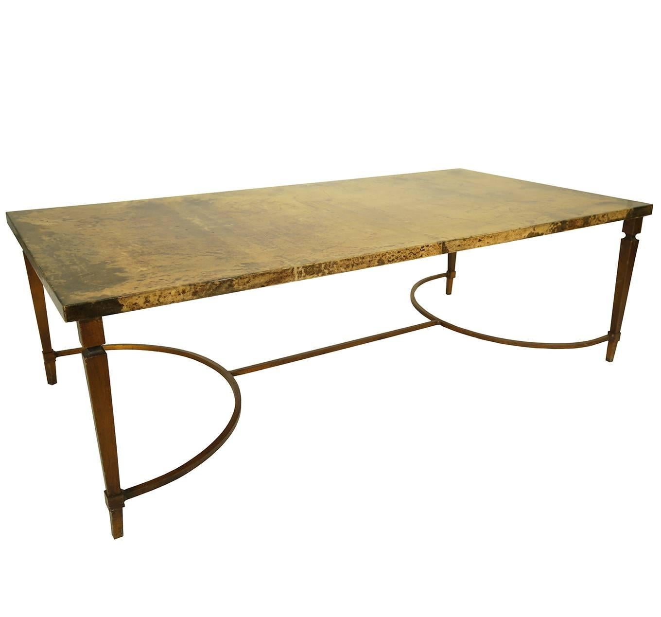 This rare 1960 Aldo Tura coffee table is an elegant statement piece.
The lacquered goatskin top is a mottled golden hue, resting on brass coated forged metal legs and stretcher.
