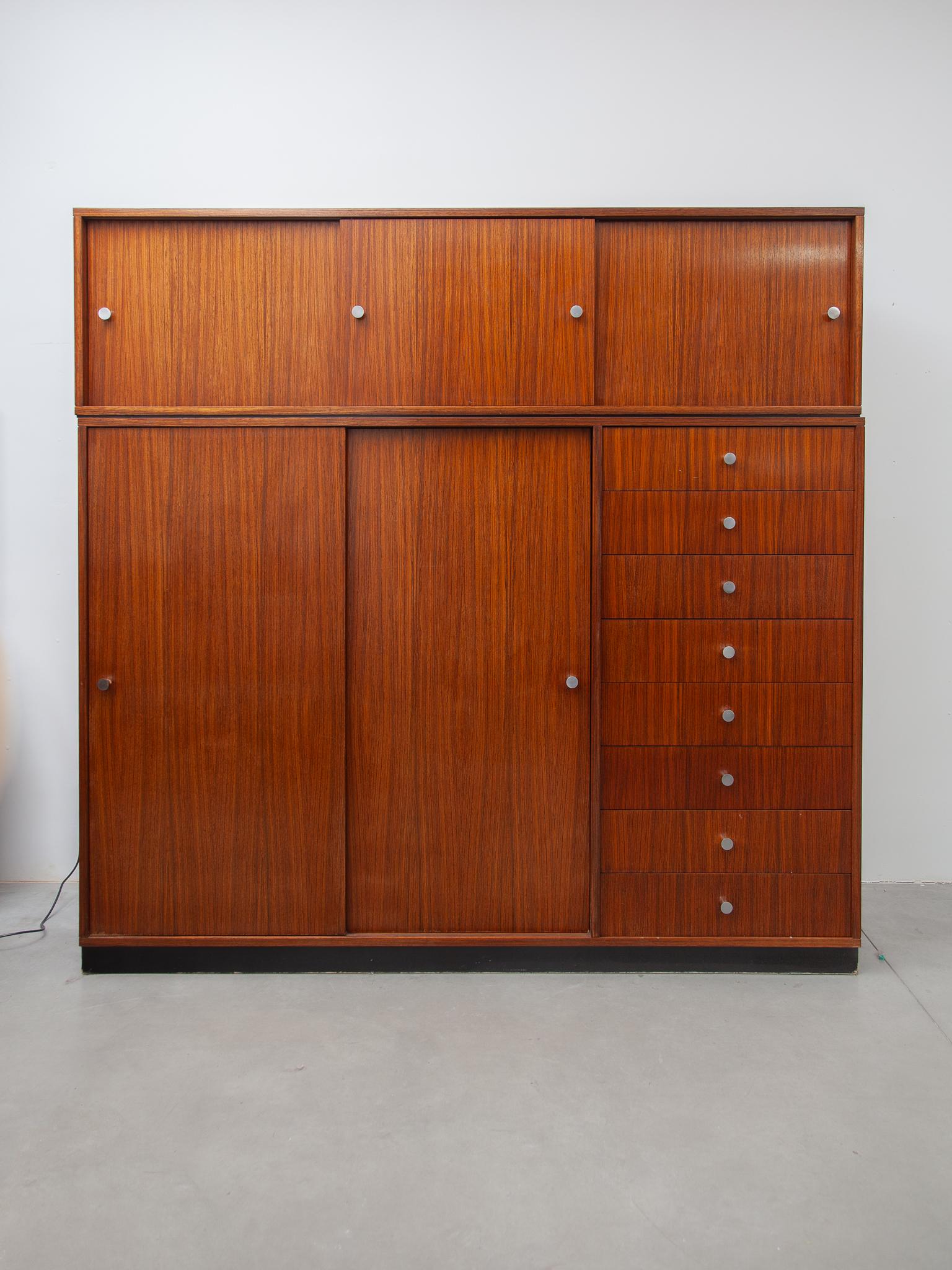 Beautiful wall unit wardrobe, cabinet designed in pure lines by Alfred Hendricks for Belform. A rare version of the design that is practical to use for a wardrobe. Beside the eight large drawers the furniture is featured into a side for hanging