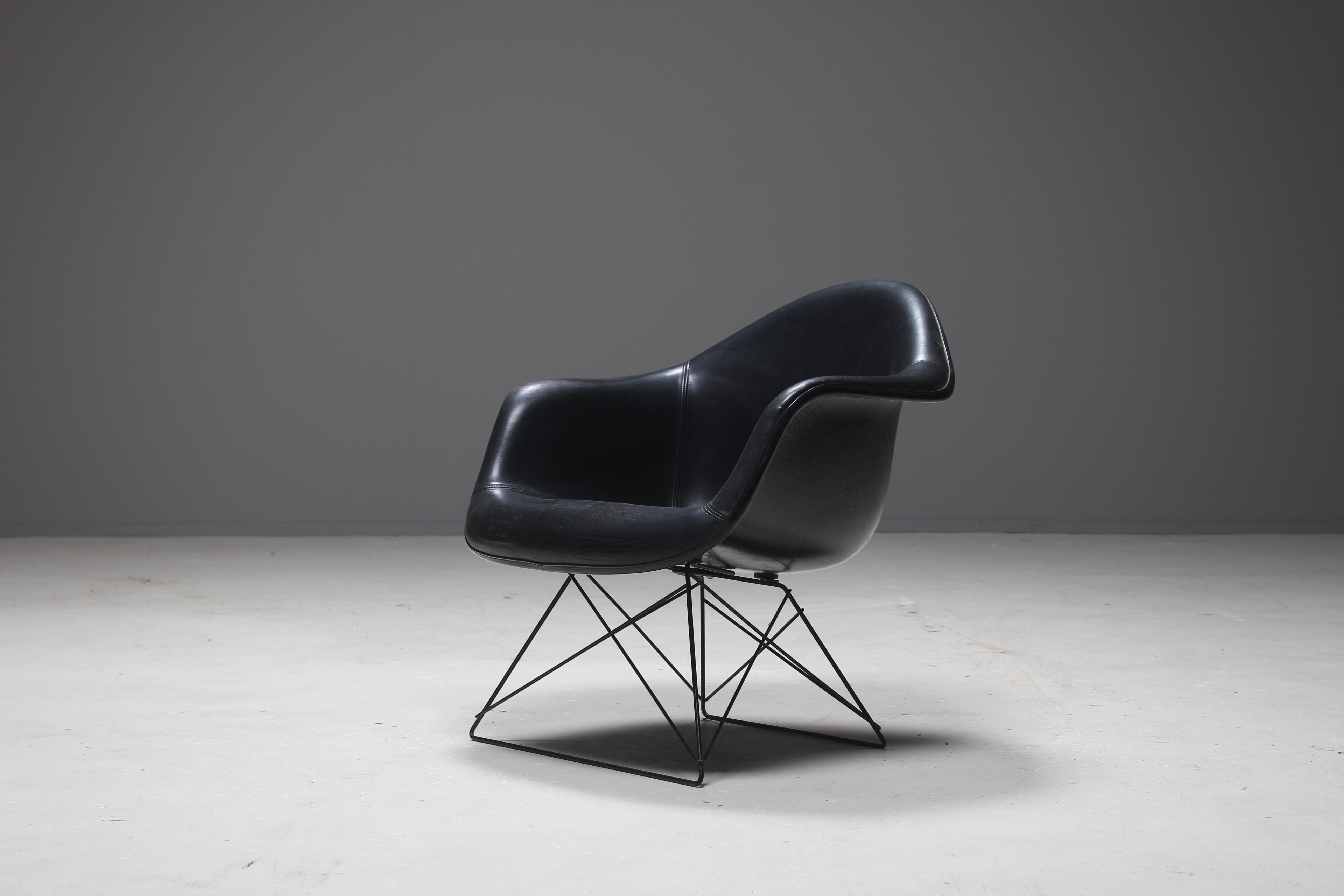 A full black original fiberglass armshell chair designed by Charles and Ray Eames and produced by Herman Miller in the USA. The fiberglass shell is upholstered with a comfortable faux leather.
A famous well known design which came in very different
