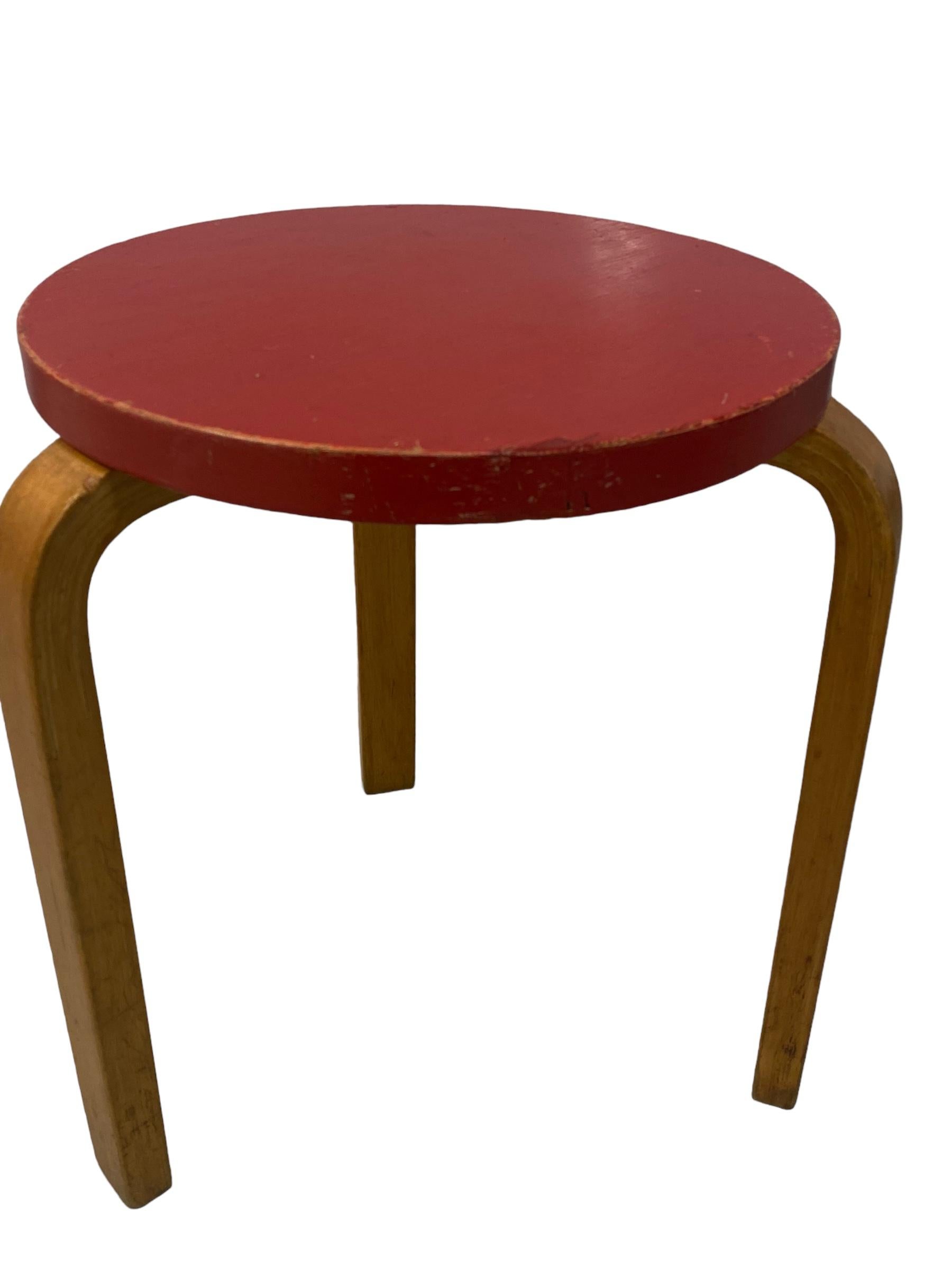 An iconic red model 60 stool in birch and beautiful patina. Designed by Alvar Aalto for Artek in the 1940s, this design has definitely stood the test of time, as it is still in production and still one of the most popular among consumers. The model