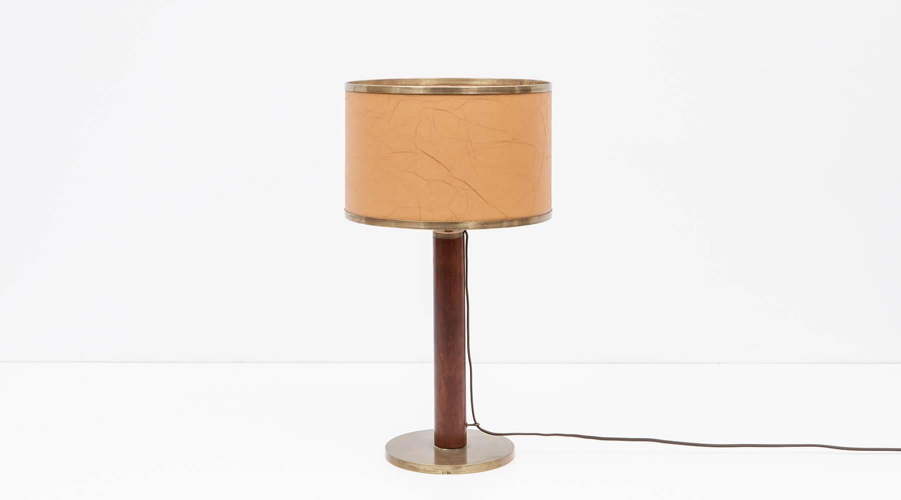 Glamorous and simply sculptural table lamp by Portuguese architect Alvaro Siza. The pole is made of wood and foot as well as the borders of the shade are brass which makes this lamp an elegant showpiece. Manufactured by DDI.
     
Considered the