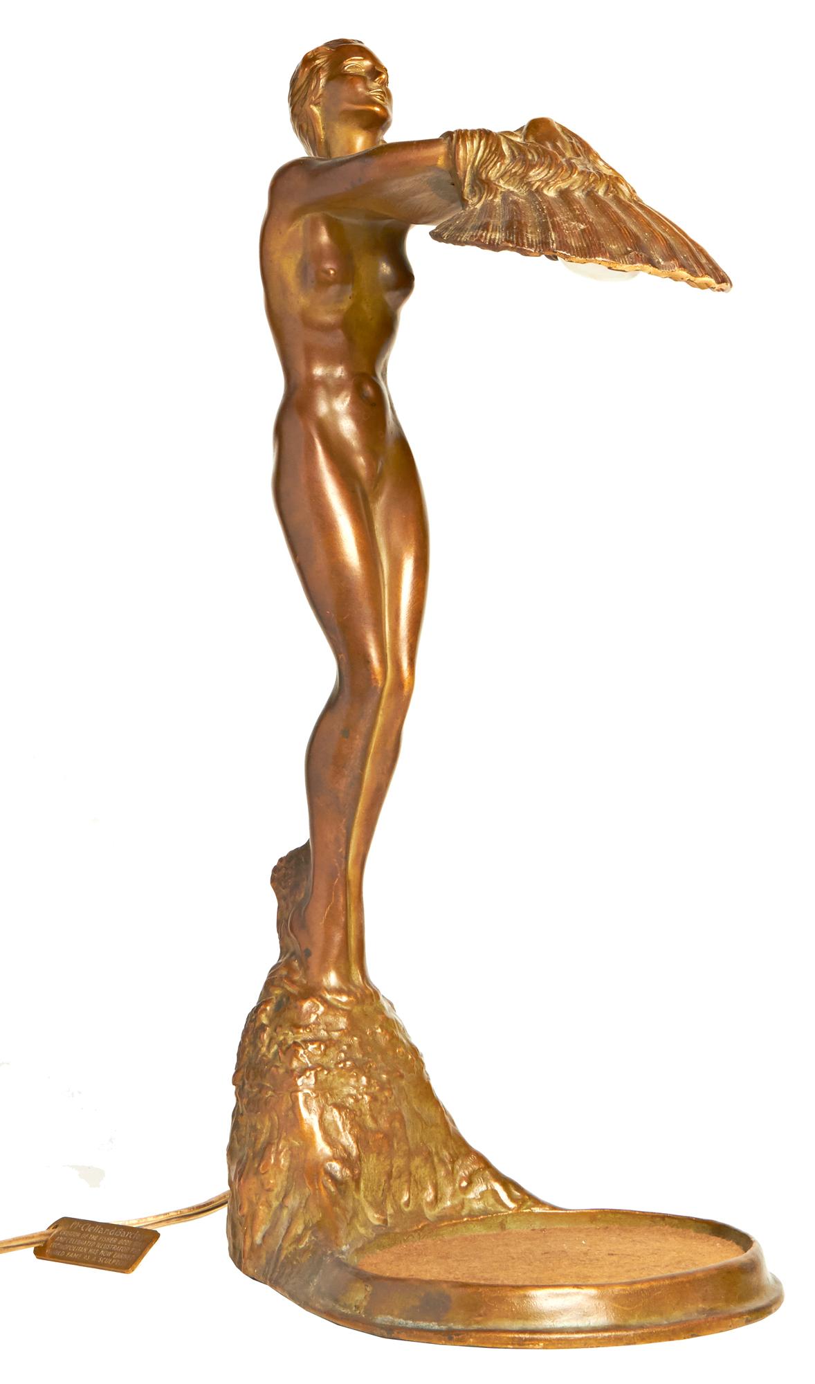 This beautifully designed, Art Deco bronzed spelter female nude with inverted shell shade is the very rare 