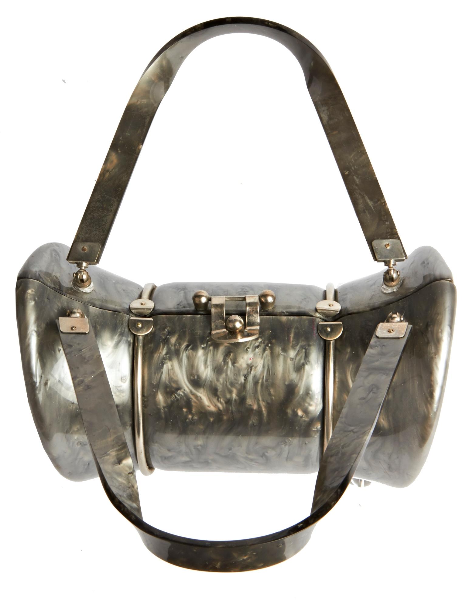This eccentrically designed American Lucite handbag is by LLewellyn Inc of Madison Avenue, New York and is part of their Lewsid Jewel range. The body and chrome hinged handles are in pearlescent marbled grey Lucite which is wrapped in chrome and