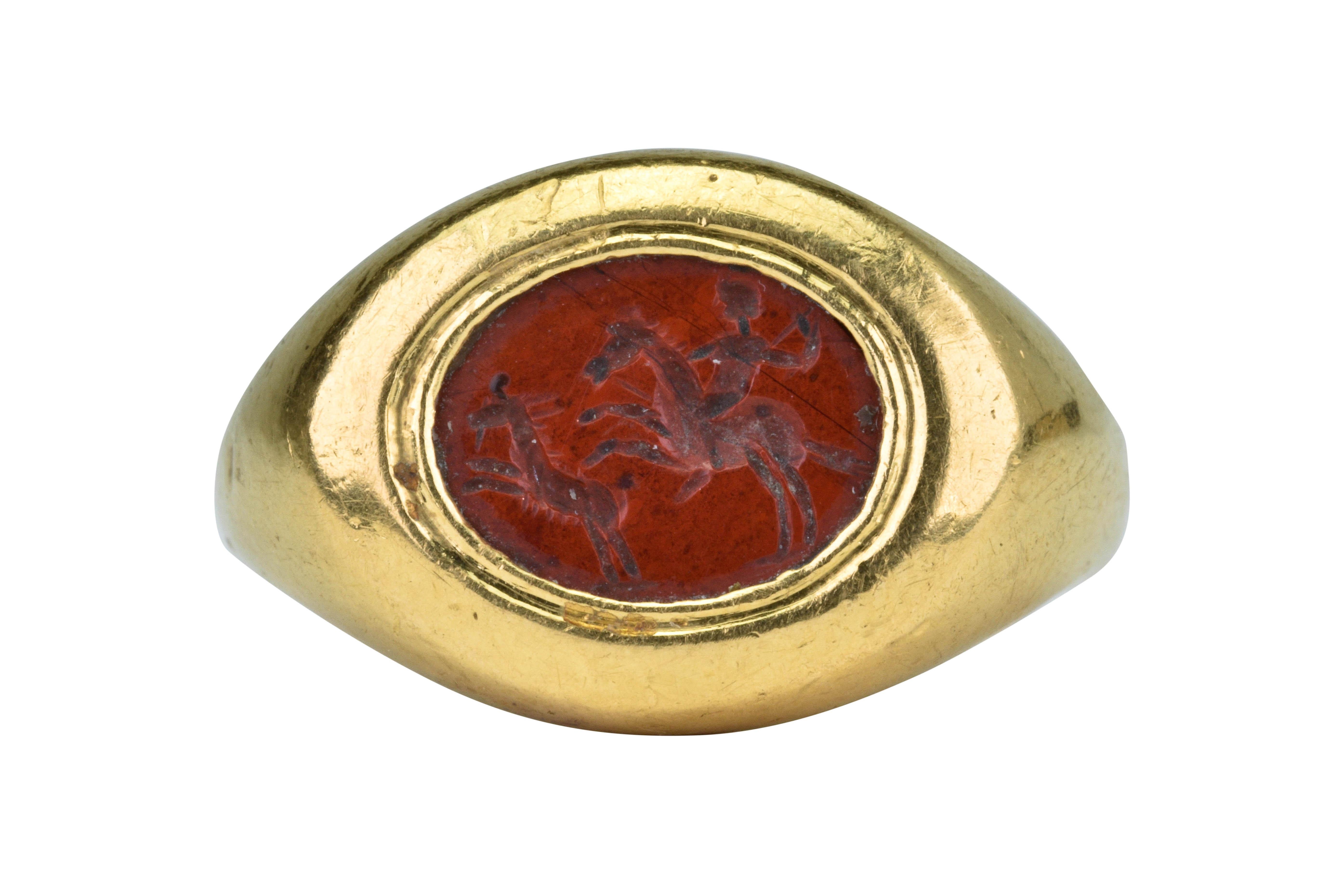 Rare Ancient Roman Gold Signet Ring with Carnelian Intaglio depicting a Hunting Scene

Ca. 100-300 AD

A rare Ancient Roman gold signet ring composed of a round, flat-section hoop with expanded and carinated shoulders; bezel containing a carnelian
