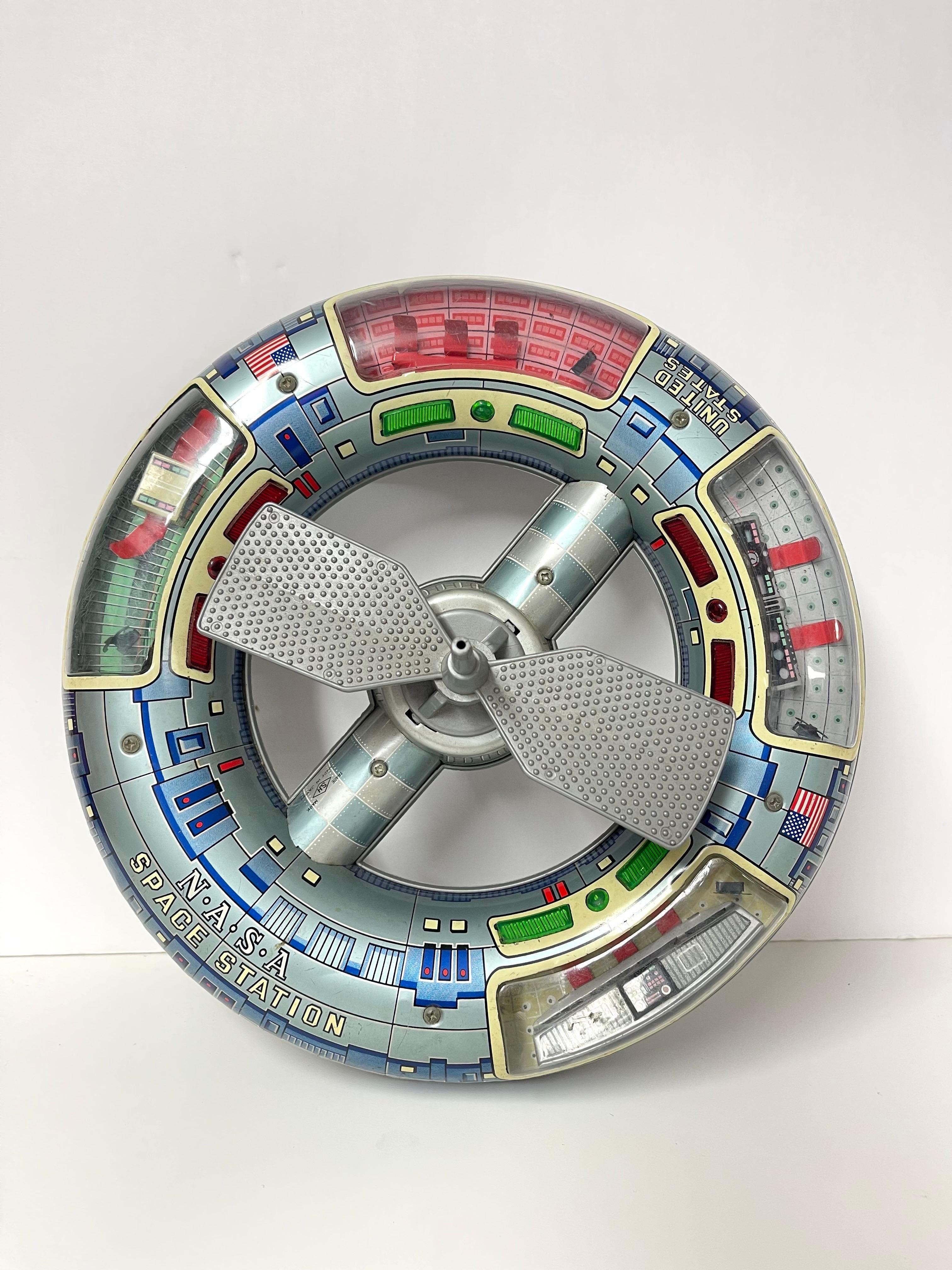 Rare et Collectional 1960's Horikawa Space Station Toy. Parfait pour le collectionneur de jouets de l'ère spatiale. Sphère en fer-blanc lithographiée avec l'inscription Nasa Space Station sur le côté, avec intérieur moulé en plastique et antenne