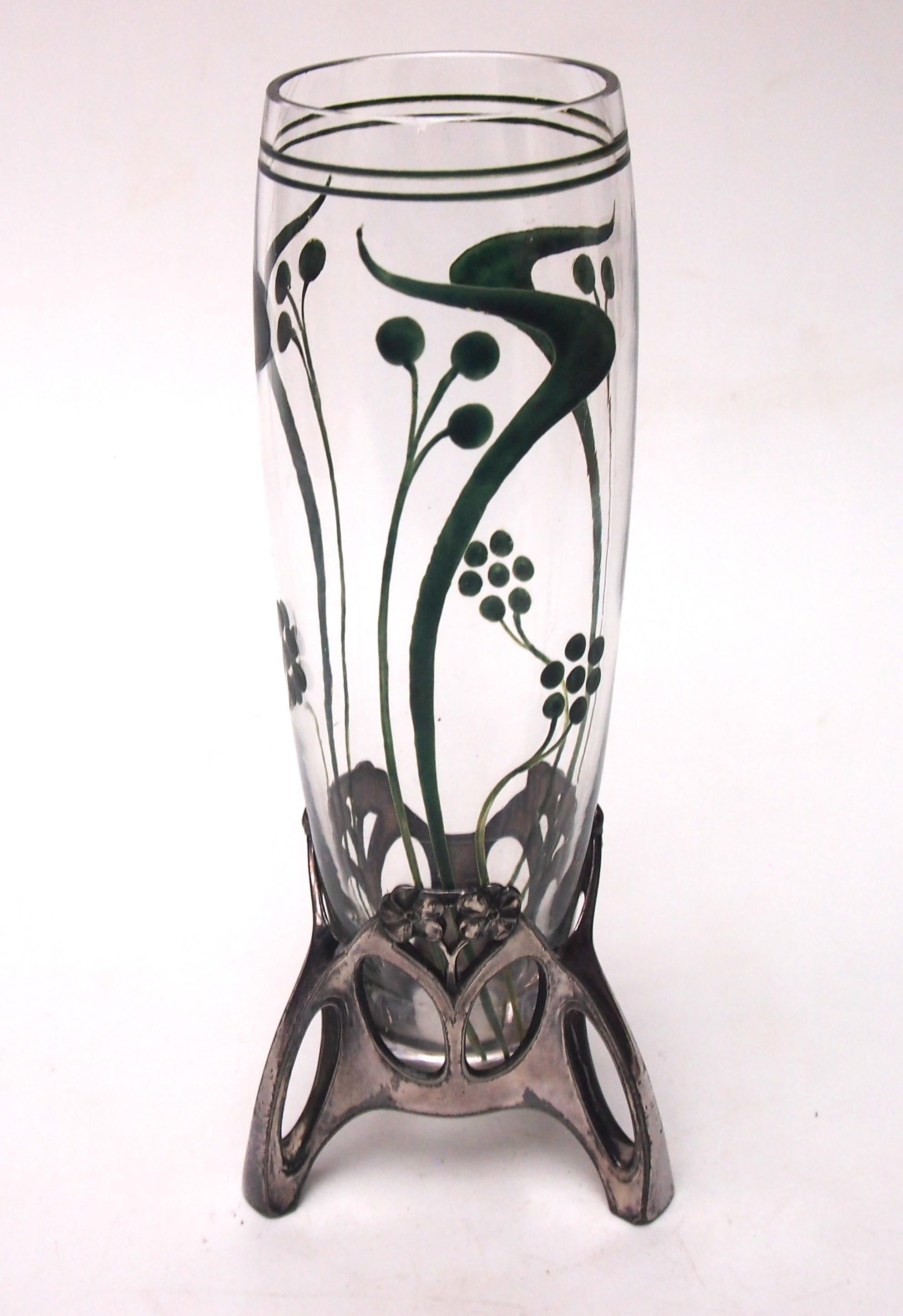 Fabuloso  Jarrón documentado de metal plateado y cristal esmaltado, firmado por WMF, en un estado excepcional. La base es de un sinuoso metal galvanizado de estilo Art Nouveau, con cabezas de flores y arcos de estilo Nouveau que sostienen la