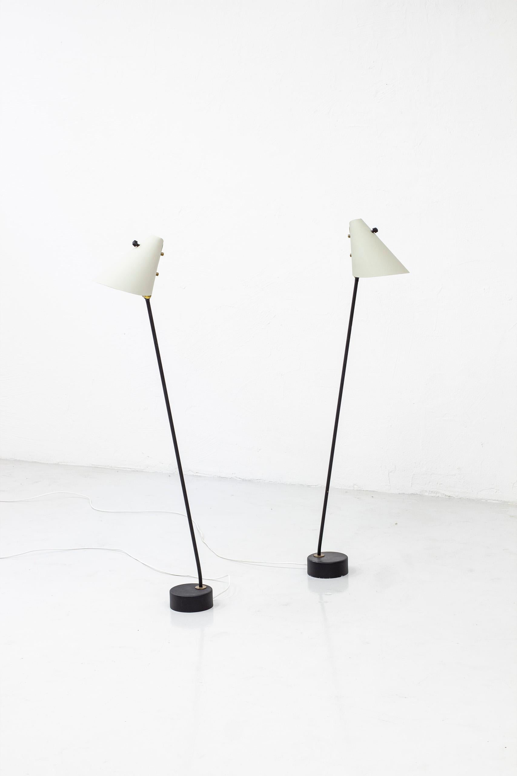Rare floor lamps designed by Hans Agne Jakobsson and Arne Nilsson. Produced during the 1950s by Hans Agne Jakobsson AB in Sweden. Mad from lacquered metal in black and grey with brass details and Bakelite light switch. Original light switches on the