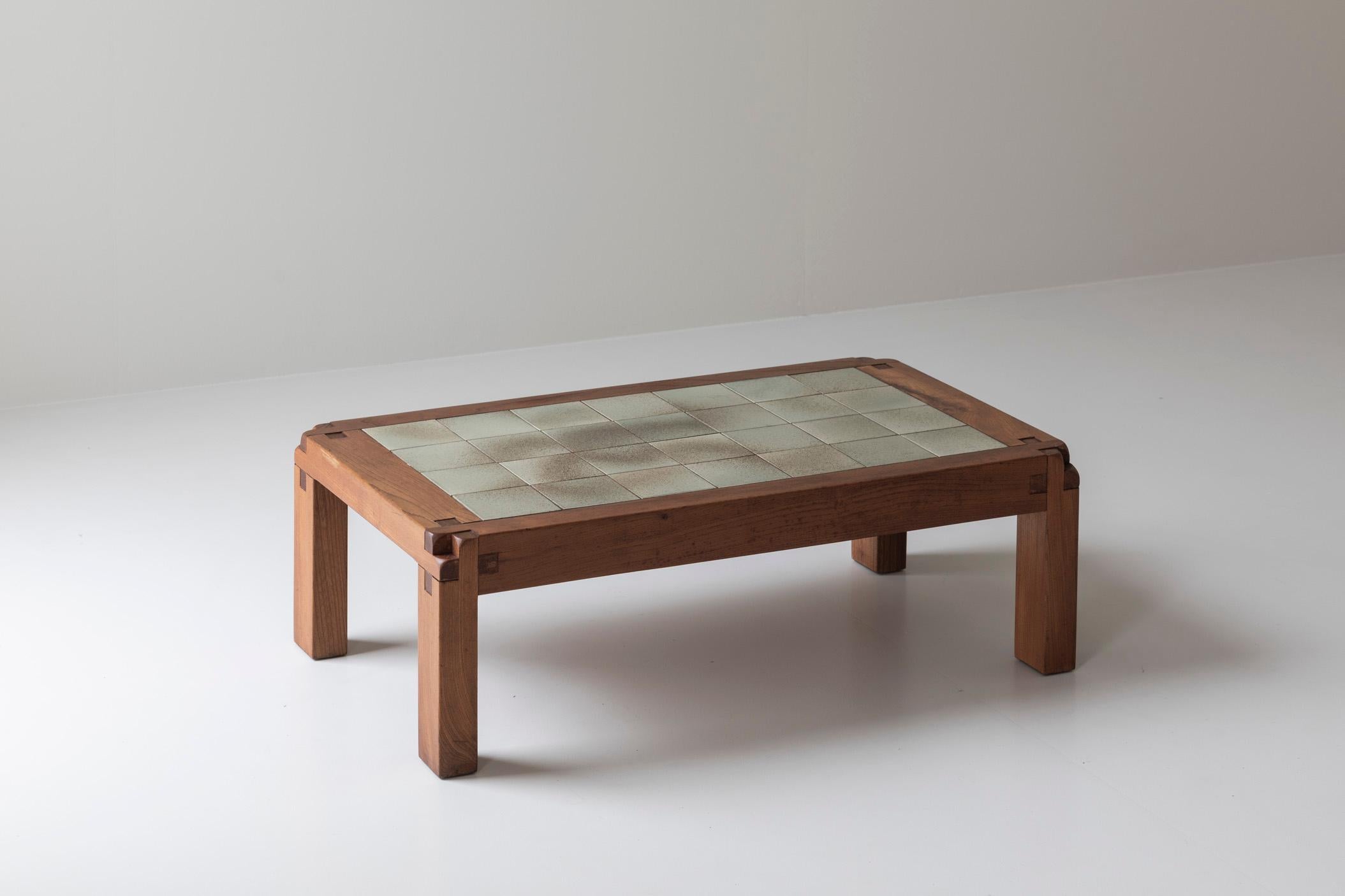 Rare and early model T18 coffee table by Pierre Chapo, designed and manufactured in his own workshop in France around 1965. This piece is fully handmade in solid elm wood with ingenious wooden joints and marvelous aged ceramic tiles on top.