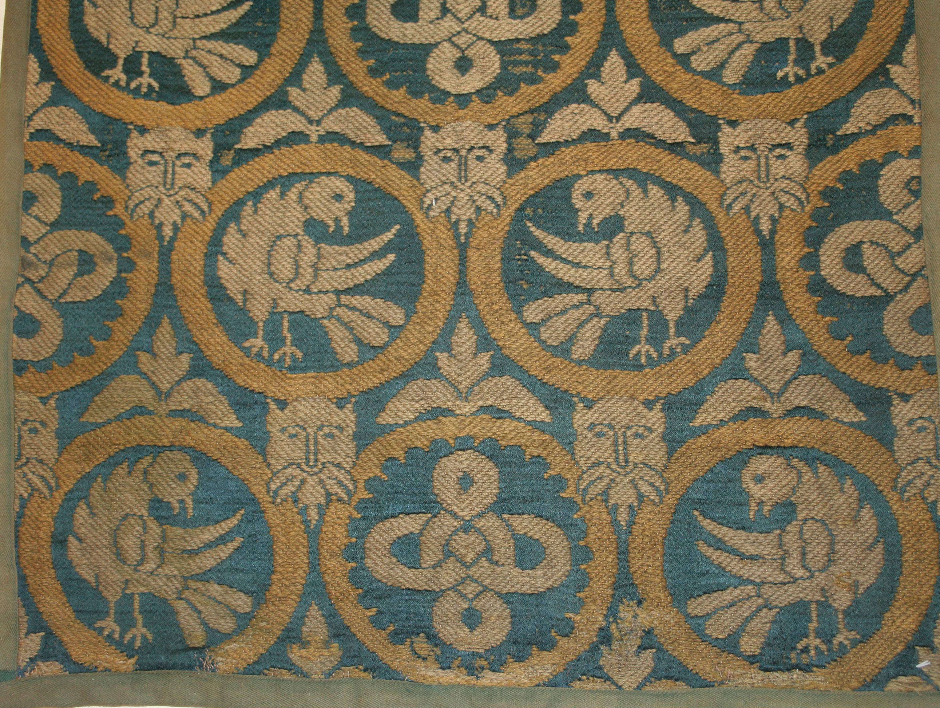 An extremely rare embroidered hanging distinguished by a repeat pattern of roundels containing confronting birds alternated to an endless knot motif, rendered in a manner typical of the British neo-Gothic movement as it appears on the work of