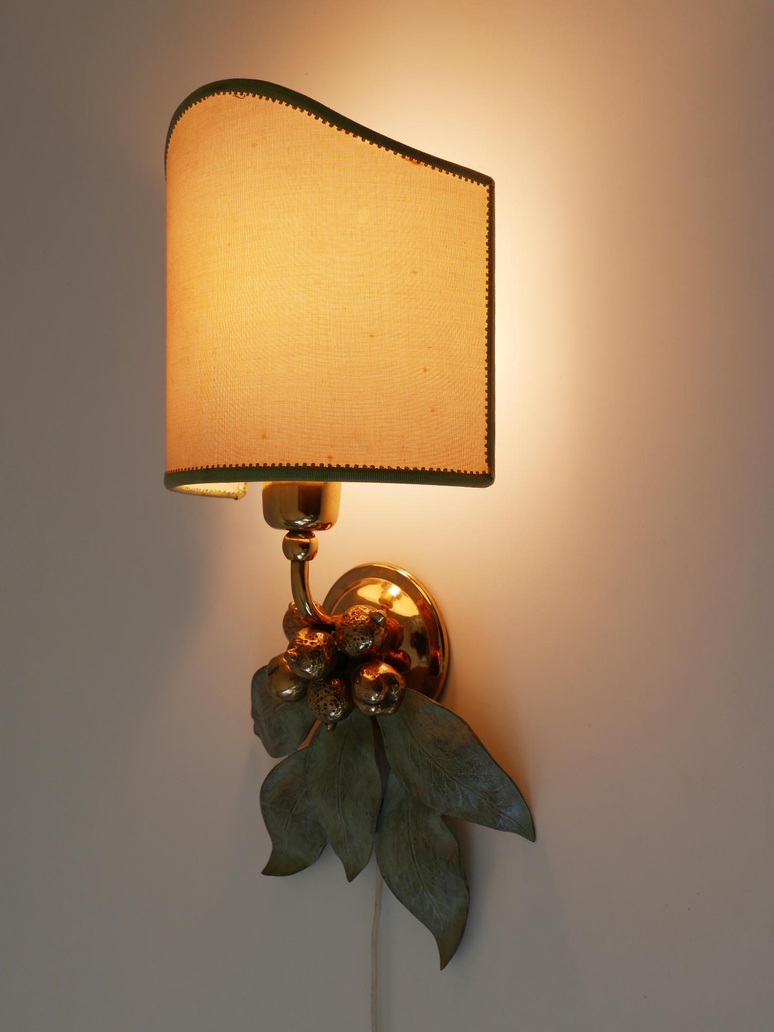 Rare and elegant Mid-Century Modern floral sconce. Designed and manufactured probably in Germany, 1970s.

Executed in bronze patinated and partly polished brass, the sconce comes with 1 x E27 / E26 Edison screw fit bulb holder. It is wired and in