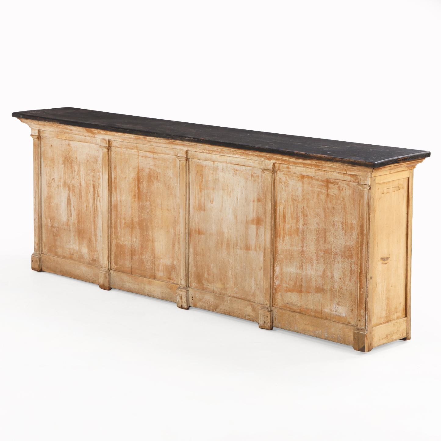 The piece features a paneled front and an open back fitted with a single small drawer over shelves, offering both display and storage. Its narrow depth makes it exceptionally versatile — ideal for use as a console table, sideboard, or kitchen