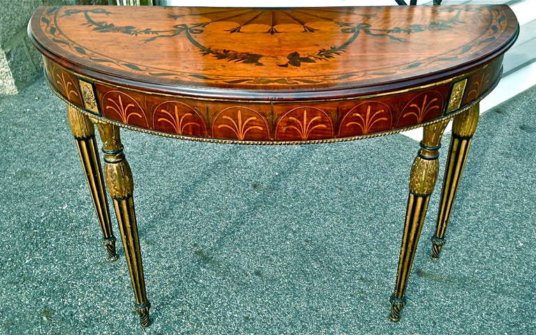 Consolle irlandese mezza rotonda in legno di raso e sicomoro, intarsiata e intarsiata, d'epoca Adam.

--Piano intarsiato con festoni e ventaglio
--Gambe neoclassiche dorate ed ebanizzate sormontate da Paterae
--Fregio con palmette
