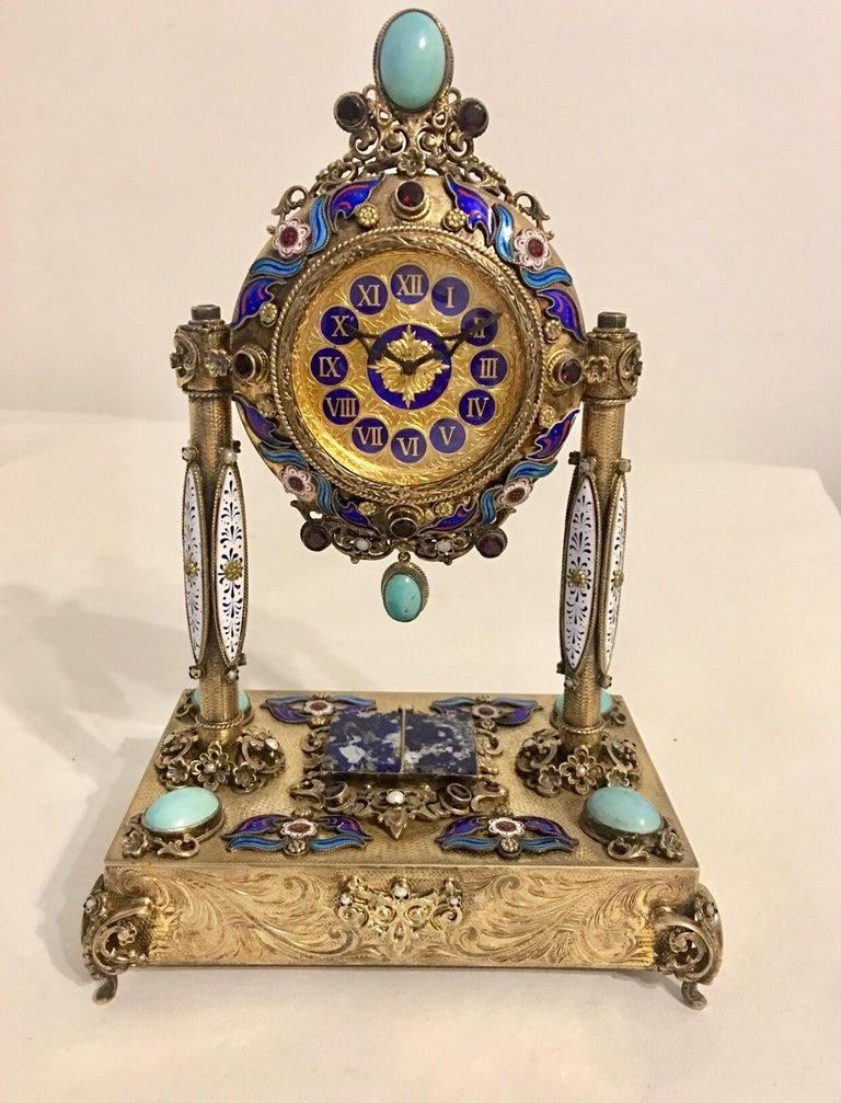 A rare and fine Viennese silver gilt, enamel, pearl and semi precious stone mounted musical table clock of portico form, made for the Chinese market. The circular case surmounted by an oval cabochon of turquoise stone, raised on a pair of columns