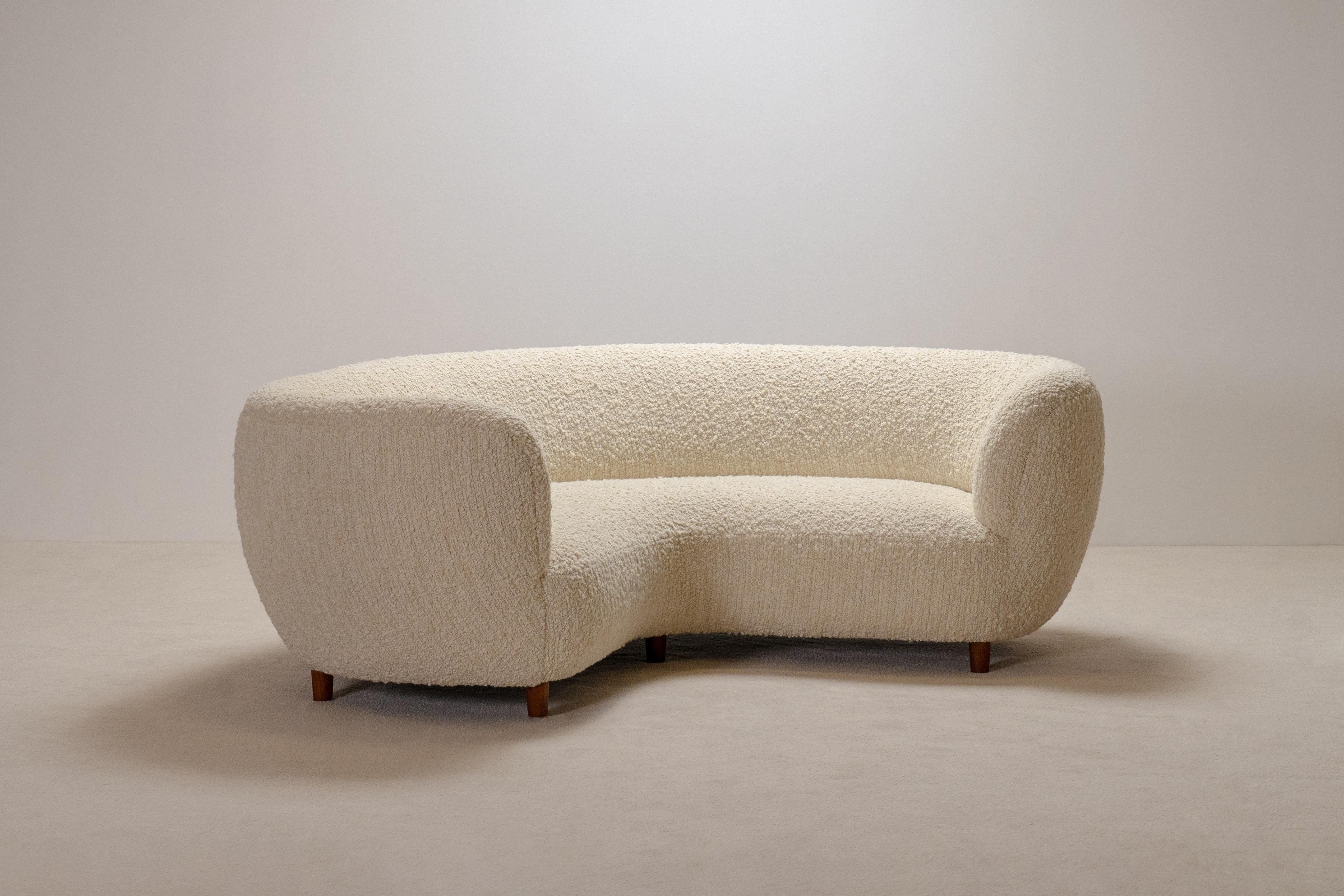 Rare and elegant three-seat curved sofa manufactured in Denmark in the 1940s.

This important sofa shows an impressive curved shape perfectly proportioned in his length and height and has seven tapered feet in solid oak.
This sofa in mint condition