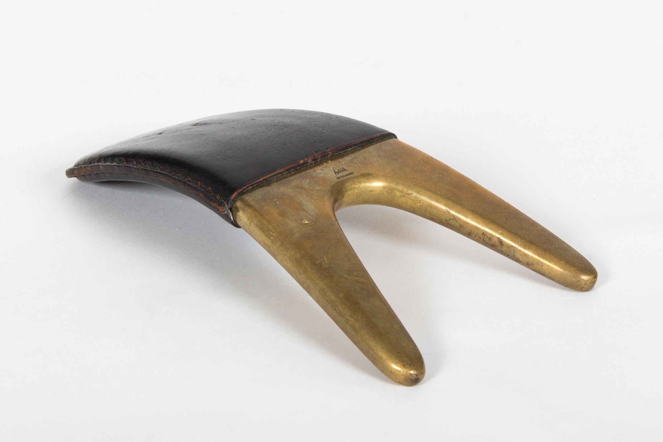 A rare collectors find from the Auböck workshop.
The well-shaped object functions as a boot jack and is made from the characteristic combination of heavy brass and leather. Marked on top, traces of ware and tear all over.