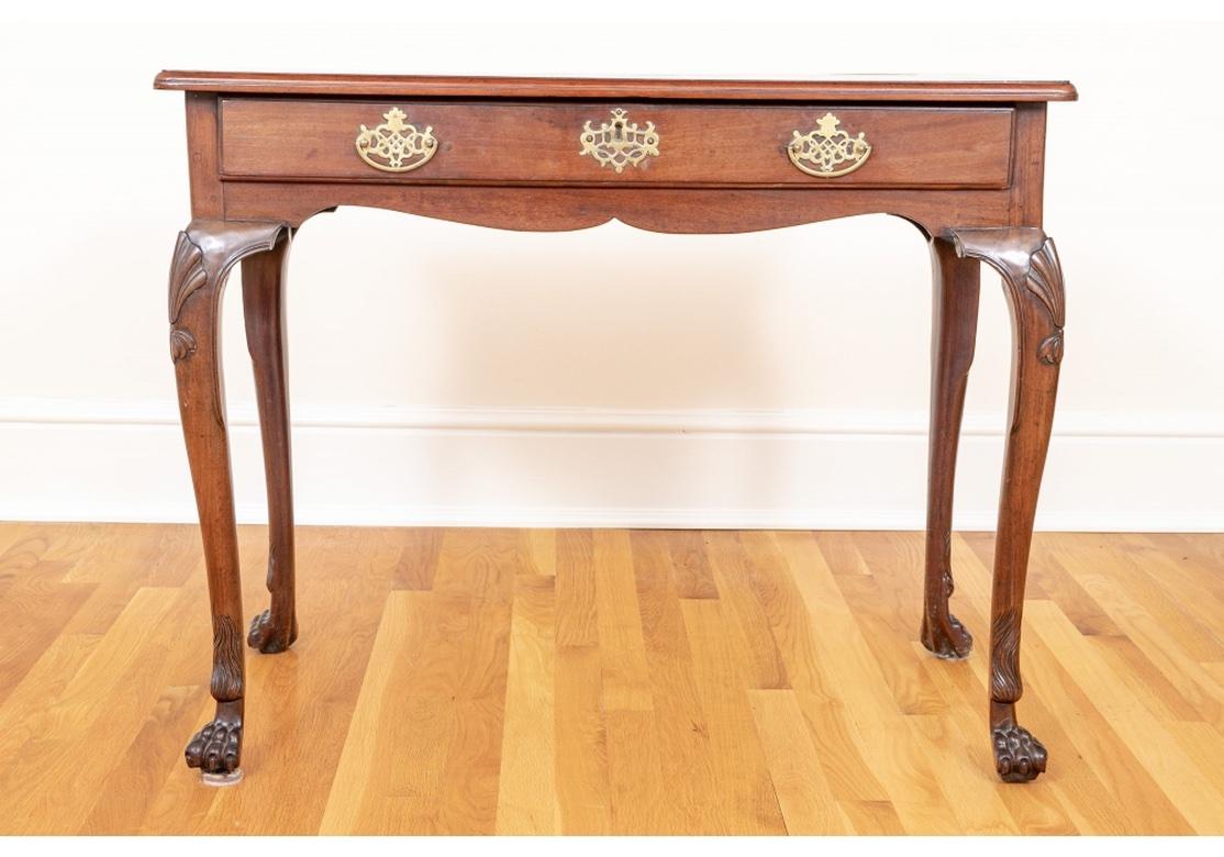 C. 1760-1780. An early and exceptional Antique writing table, English and likely Irish. With a  flame mahogany banded top over a shaped apron with a single drawer. With fine openwork brass bales and escutcheon (lacking a key). Raised on all cabriole