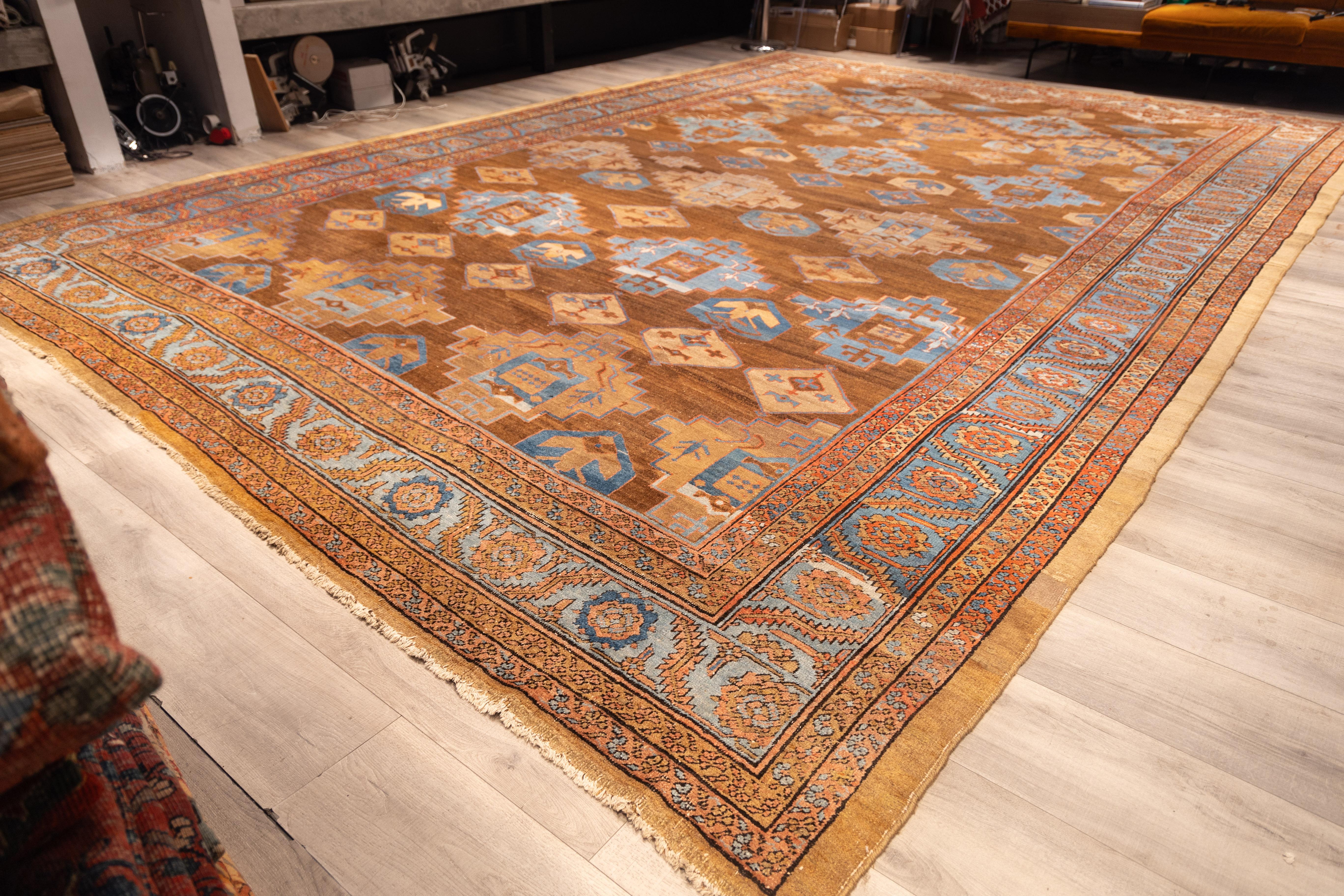Rare Bakhshayesh camelhair carpet from the 19th with bold tribal geometry and subdued, organic color. The field—woven in lustrous, undyed camelhair—displays a striking lattice of stepped medallions and diamond motifs, rendered in sky blue, brick