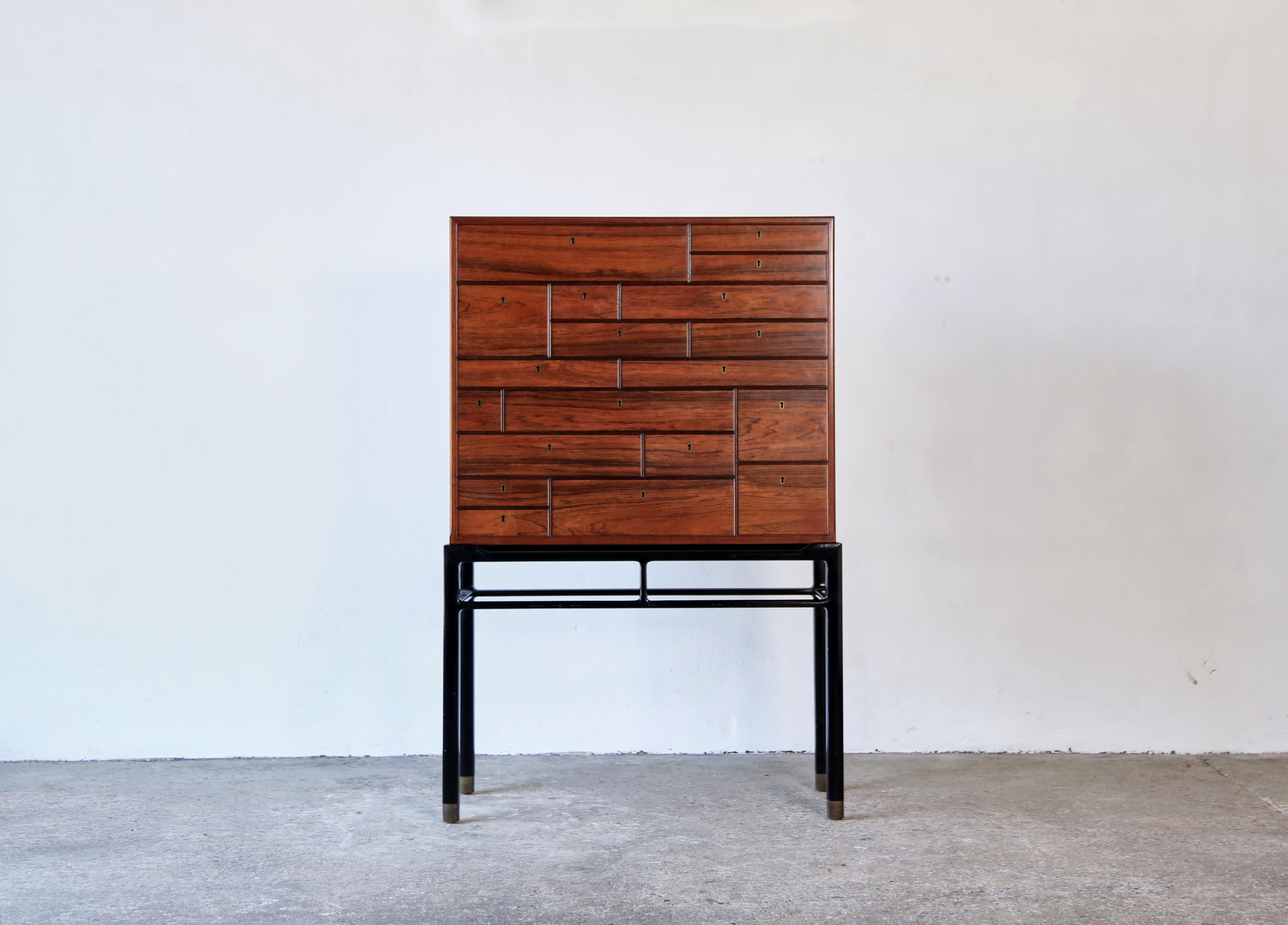 A rare and important Jørgen Berg cabinet-on-stand, model no. 24190, executed by master cabinetmaker William Christensen, Denmark, in the 1960s for luxury Danish department store Illums Boighus, Copenhagen, Denmark.   Rosewood-veneered wood, 19