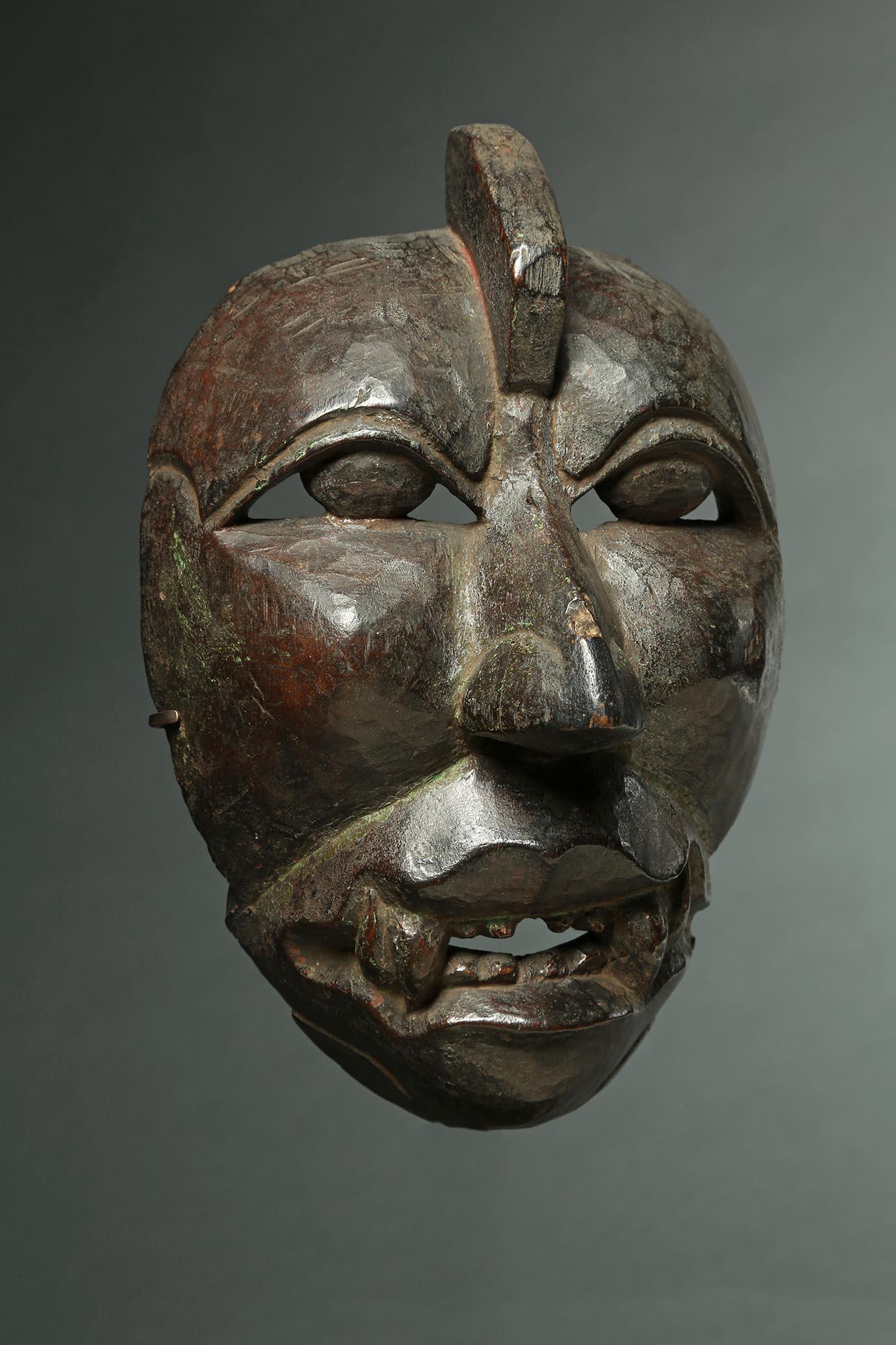 A very scarce and very old mask, with open mouth, eyes and fangs. From the Dieng Plateau area, Central Java, Indonesia, 19th century, possibly 18th century. Wear to edges and very deep patina inside from extensive use in ceremonies and dances.