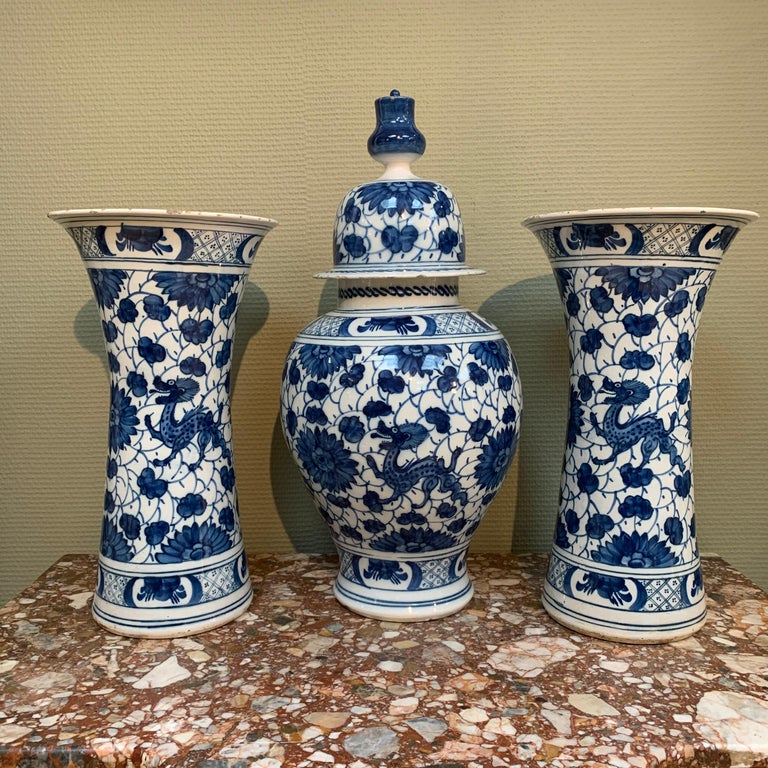 A rare and large Dutch Delft garniture of two side and one middle vase, decorated with dragons.

Origin: Delft, The Netherlands
Date: 1700 - 1750
Workshop: possibly De Griesche A (The Greek A)

A unusual and large three piece garniture with