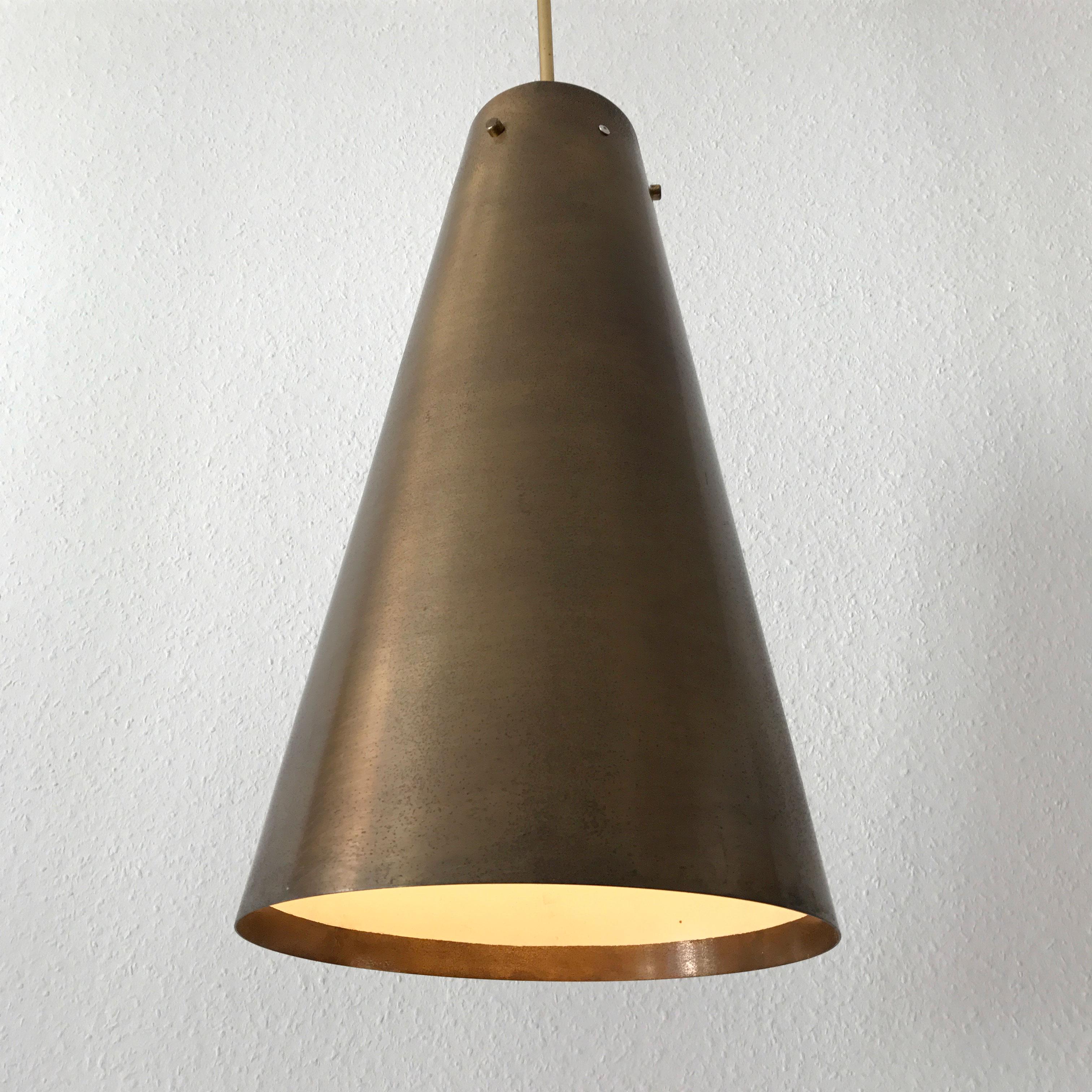 Stunning Mid-Century Modern brass pendant lamp. Designed and manufactured in 1950s, Germany.

The lamp is executed in brass and has 1 x E27 Edison screw fit sockets. It is wired, and in working condition. It runs both on 110 / 230