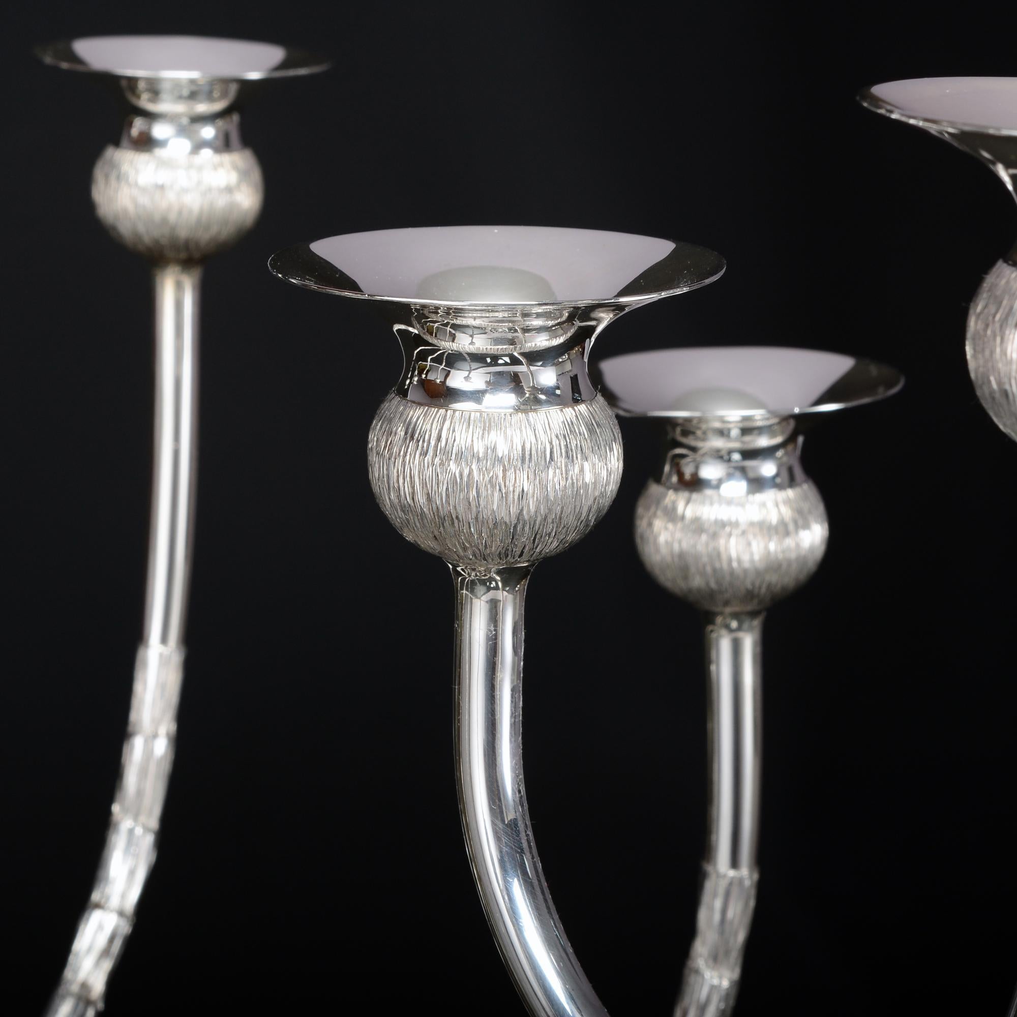 An impressive and unique silver nine-light candelabrum or centrepiece made by the prominent and highly regarded 20th century silversmith, Gerald Benney, in 1976.

The silver candelabrum is formed as seven thistle stems converging to form a sphere