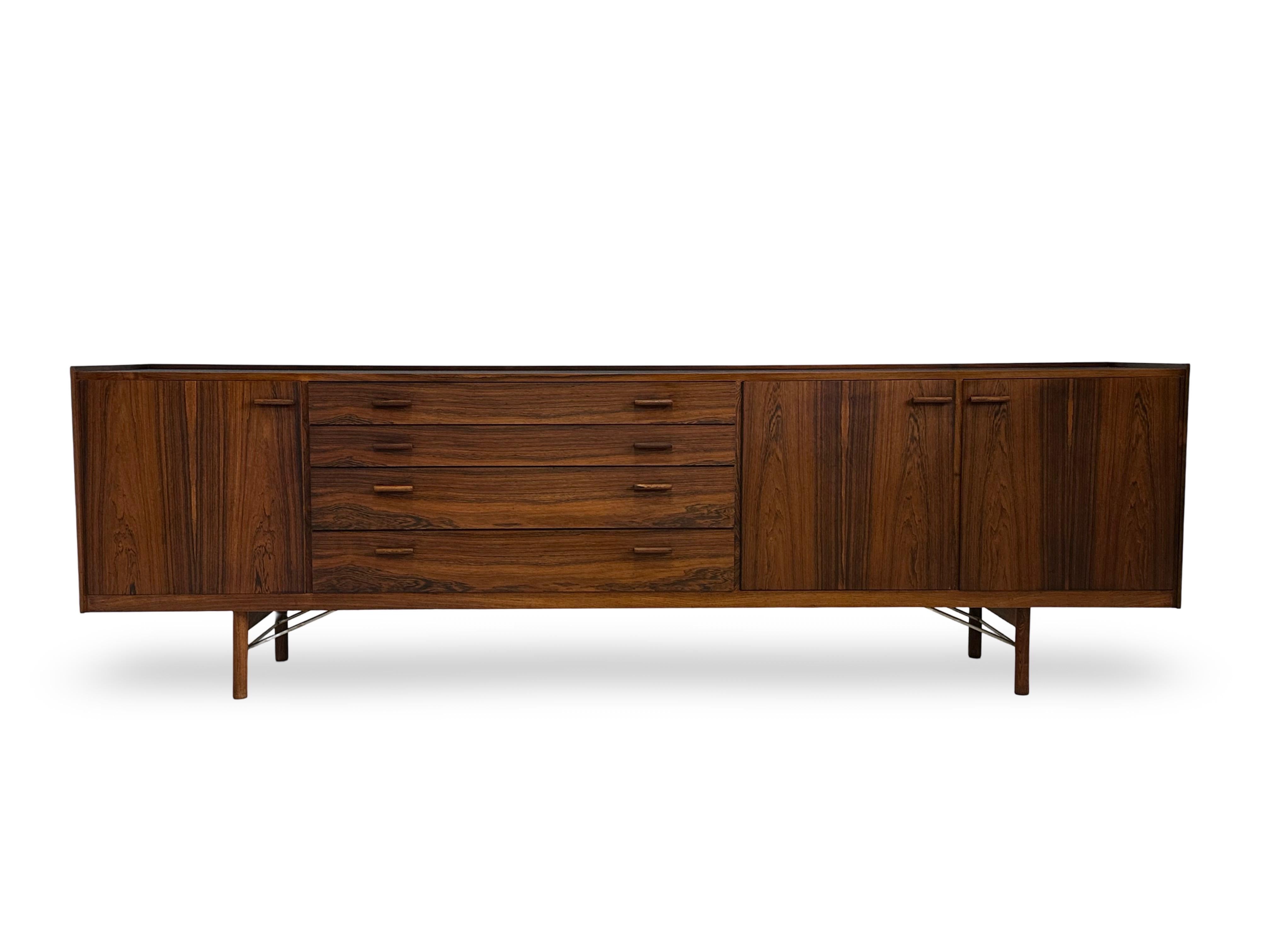 Grande credenza bassa in palissandro disegnata da Ib Kofod-Larsen nei primi anni '60 e prodotta da Brande Møbelfabrik, Danimarca.
Modello indipendente con schienale impiallacciato.
