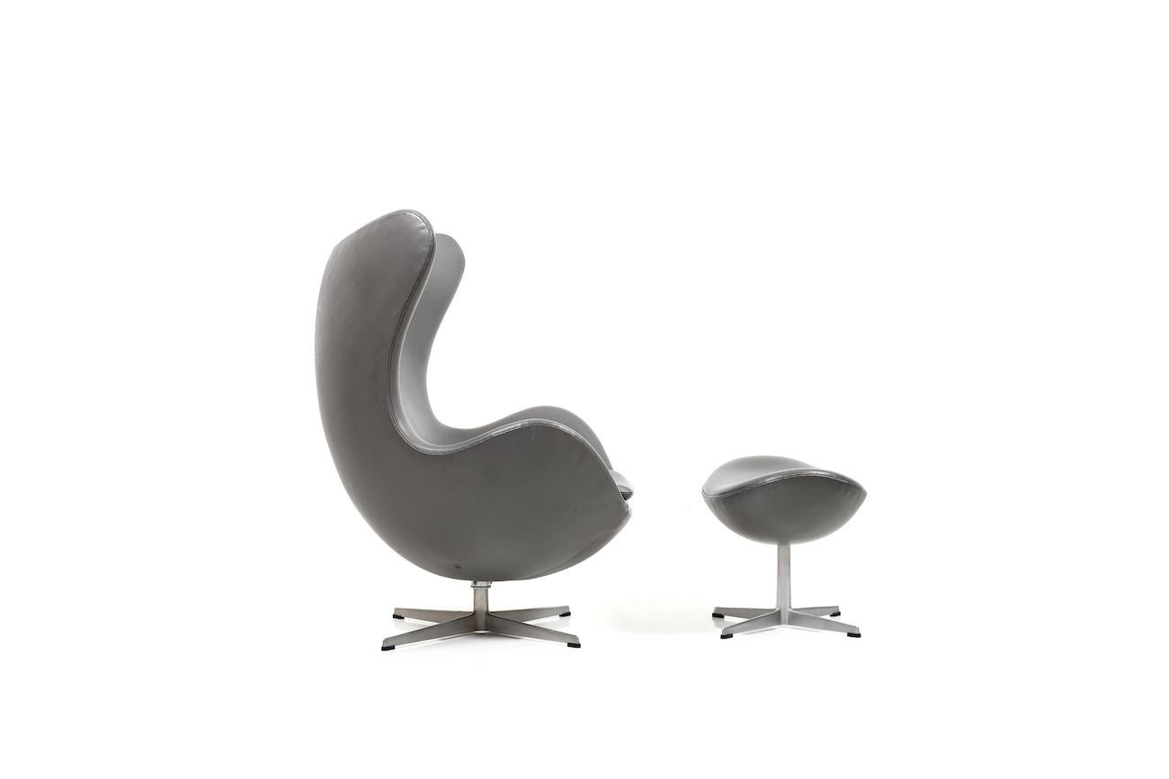 Selten angebotener Ruhesessel / Egg Chair mit Fußhocker, Modell 3316 / Modell 3317. Old Edition mit Rückholmechanismus / Kippfunktion. Gepolstert mit hochwertigem Arne Sörensen Leder in Elefantengrau. Die Oberfläche des Leders hat ein schönes