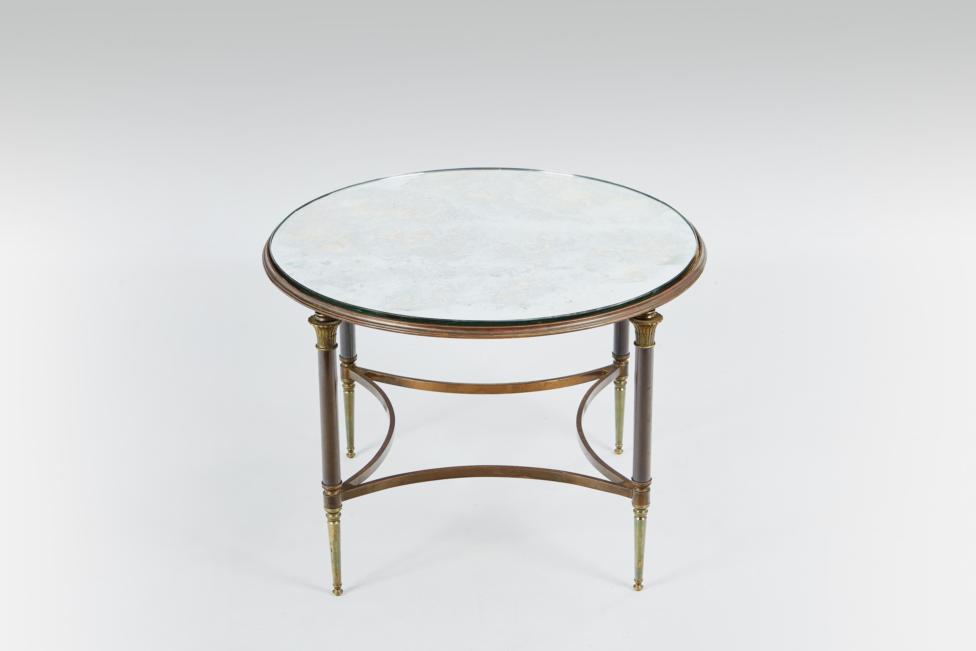 1950s rare & signed (“Jansen, 9 rue Royale”) Maison Jansen circular occasional table, in bronze and brass, with inset églomisé glass top which sits on four Corinthian capital topped legs.

Not all Jansen produced furniture and objects were signed.