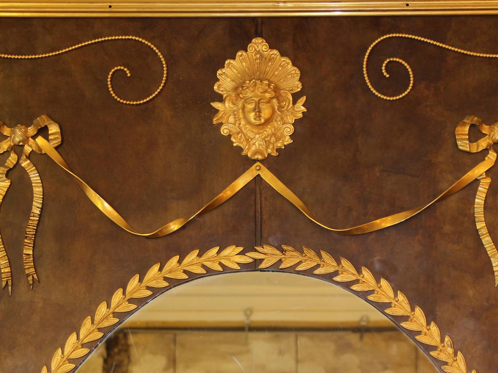 Ungewöhnlicher und großer Holzspiegel, ganz aus patiniertem Messing, mit Ornamenten aus vergoldetem Messing und vergoldeter Bronze. Der ovale Spiegel im Inneren ist ein originaler Quecksilberspiegel, der einige Kratzer aufweist. Die Rückseite des