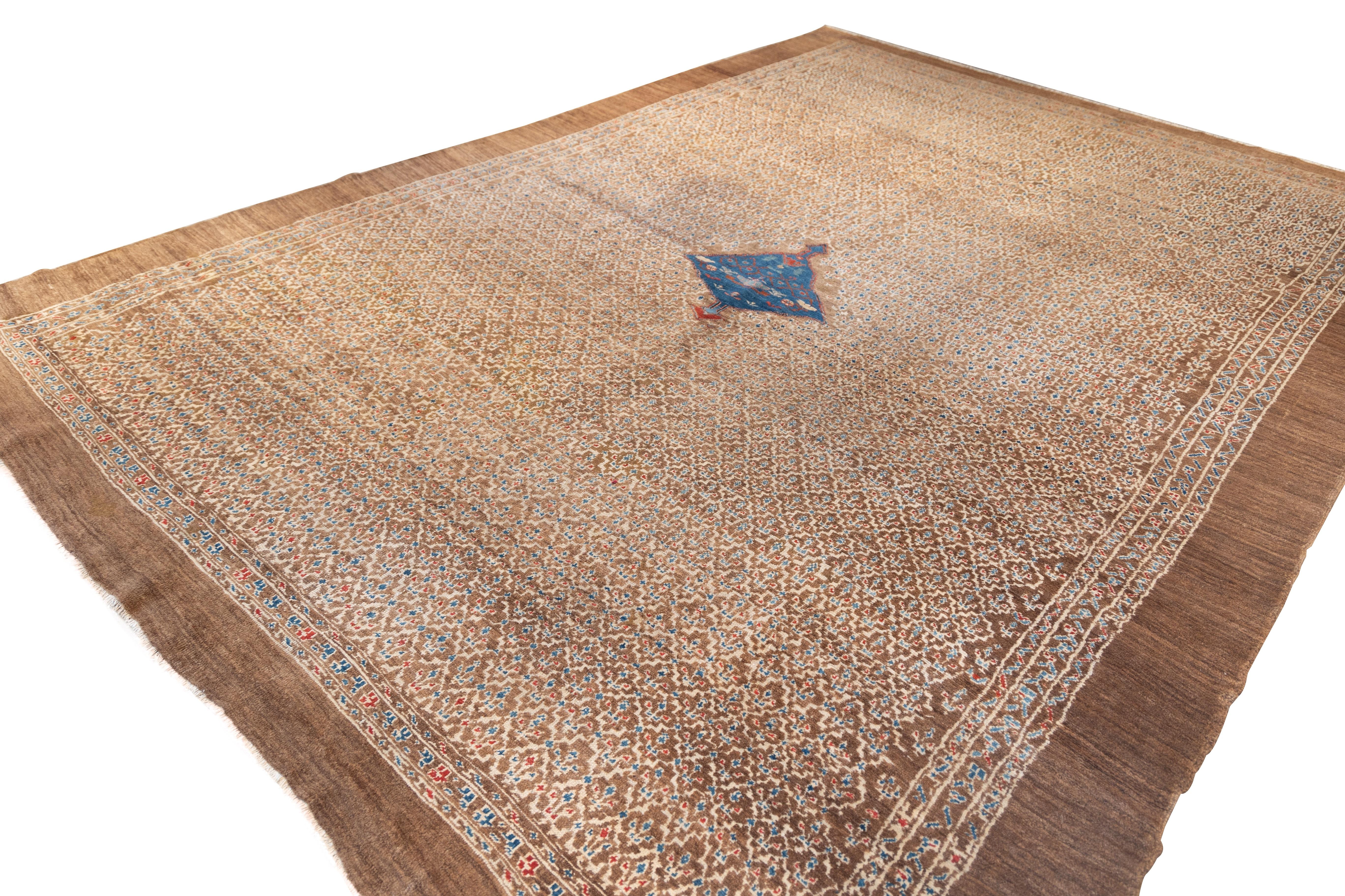 Rare a 19th century camel field Bakshaish featuring a fine, allover lattice of tiny ivory tribal motifs on a warm, coppery brown ground. A single primitive rich blue diamond medallion floats in the center, adding contrast and focus. Delicate white