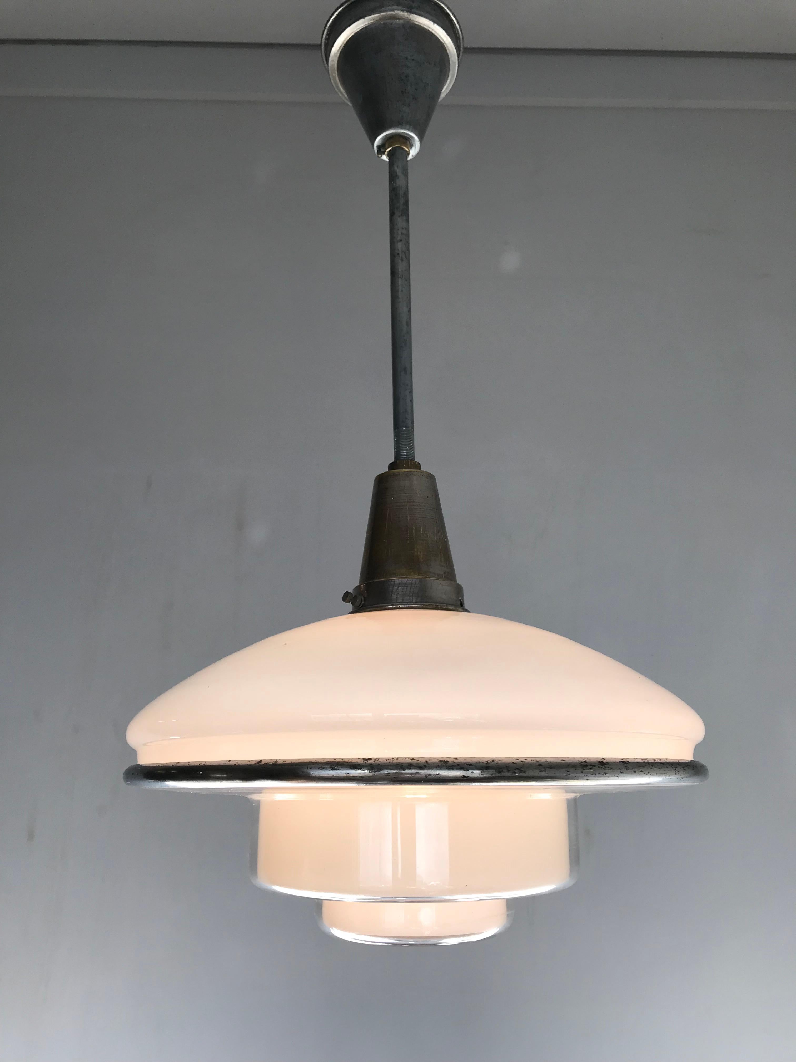 1920s Bauhaus style light fixture with original rod and canopy.

This stunning Otto Müller for Sistrah pendant is in very good to excellent condition and thanks to its shape this timeless piece of lighting art can be used in various kinds of