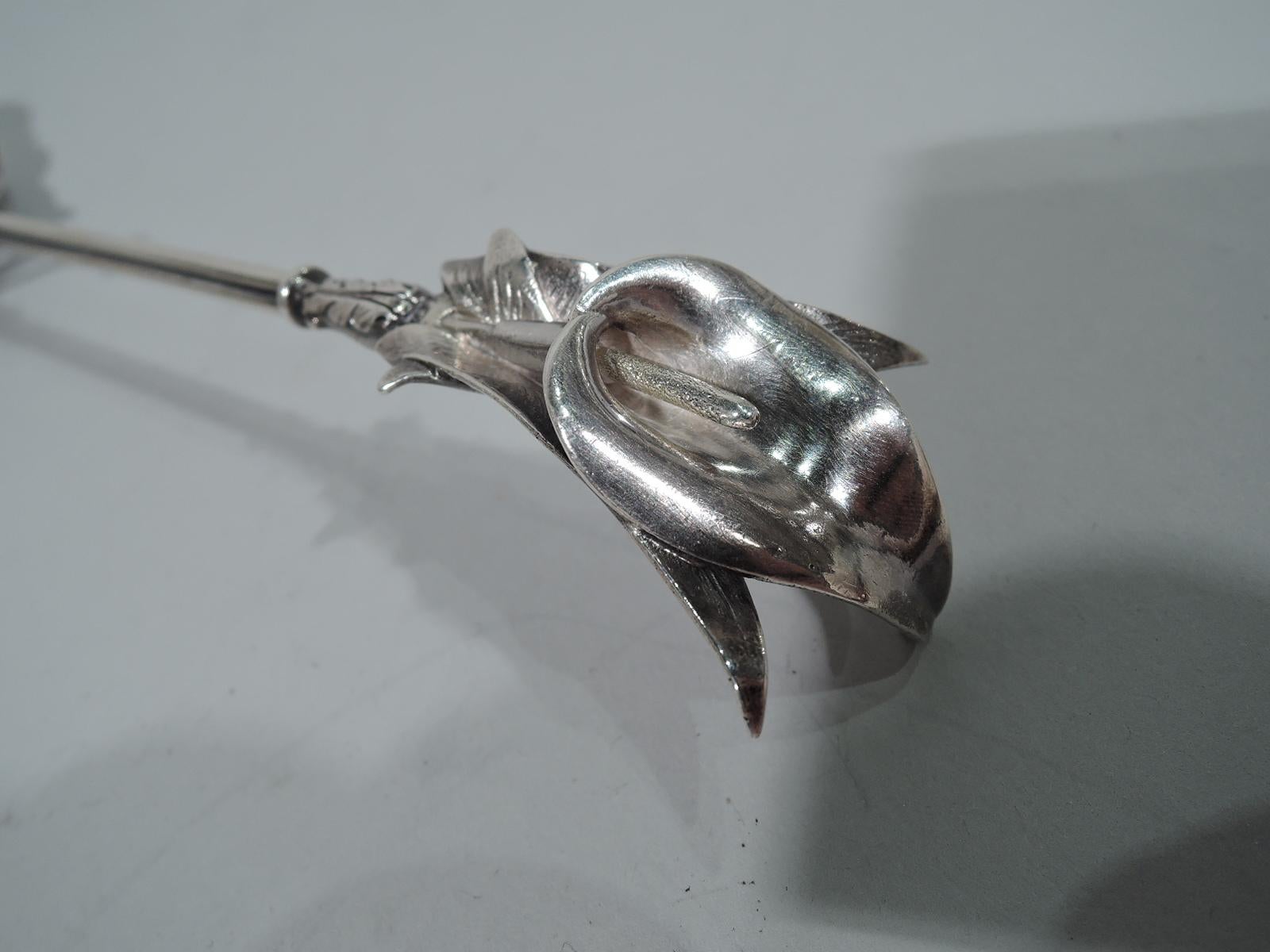 Rare and stylish sterling silver Calla Lily serving spoon. Bound wire shaft with sculptural terminal in flower form with stamen set in petals mounted to overlapping leaves. Shaped and shallow bowl with butler-finished interior and three-leaf mount.
