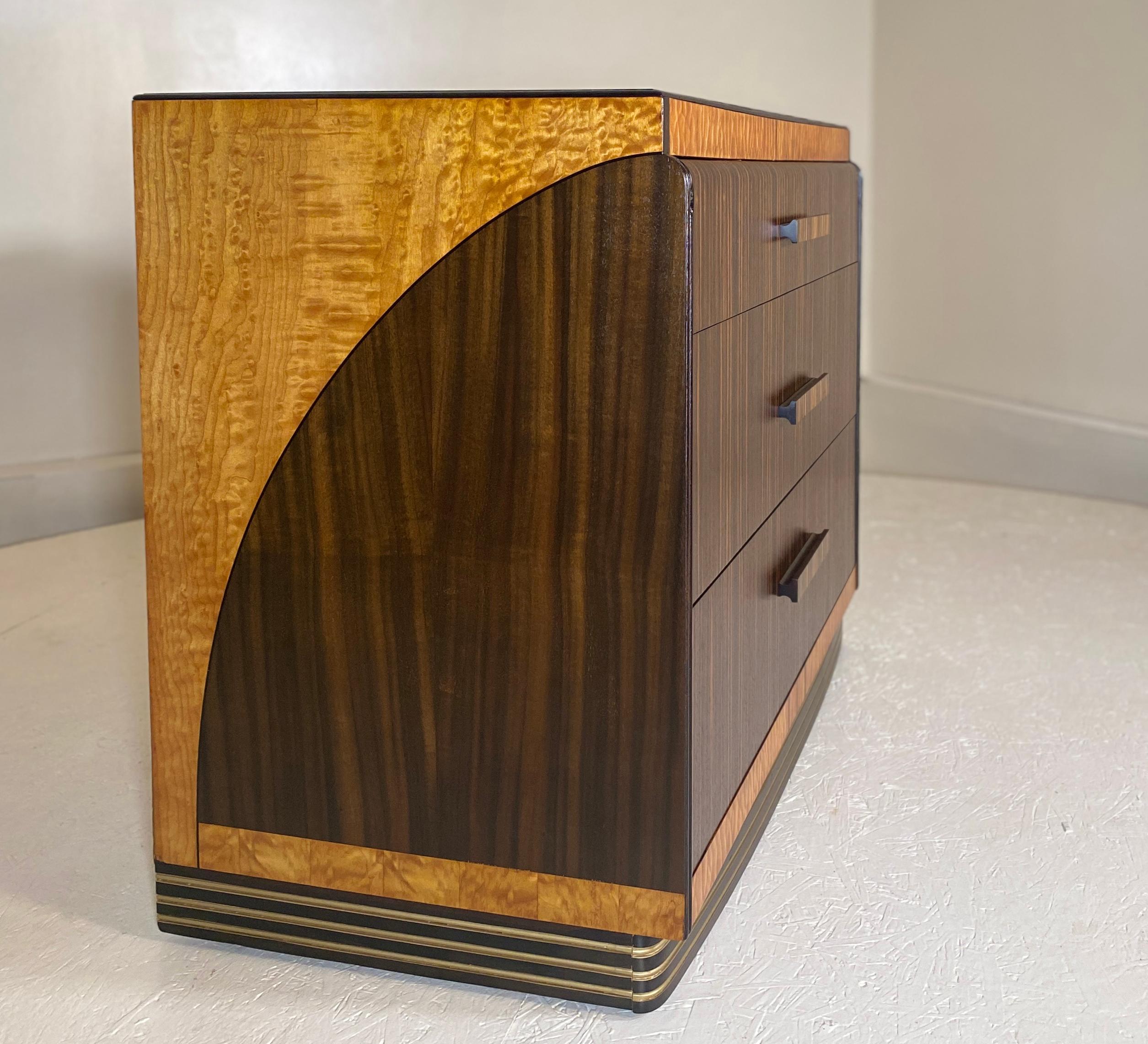 A unique and rare piece by Leo Jiranek circa 1930-1935 and signed. Produced with premium Macassar Ebony, Birdseye Maple, Mahogany and bakelite and original blue mirror glass silvered top. This unique dresser differs from the pieces seen by Leo