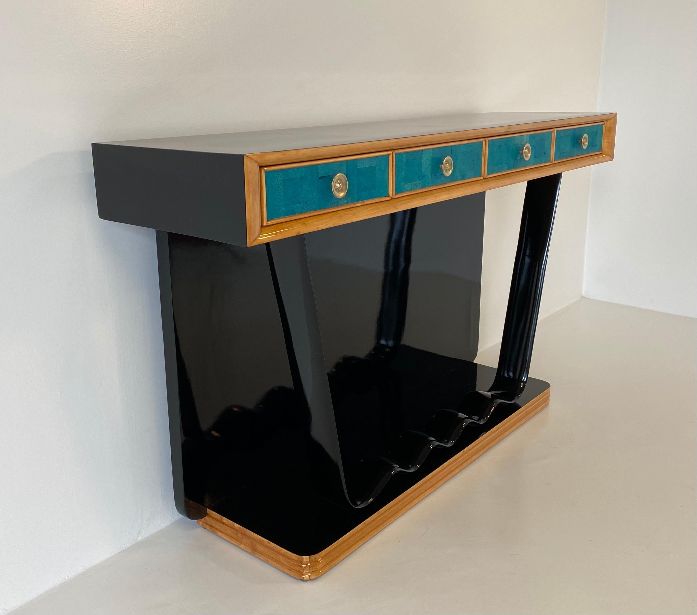This console was produced in Italy in the 1940s, most likely based on a design by the architect Osvaldo Borsani.
It is entirely in black lacquered wood with solid maple profiles.
The front of the drawers are covered in precious blue shagreen