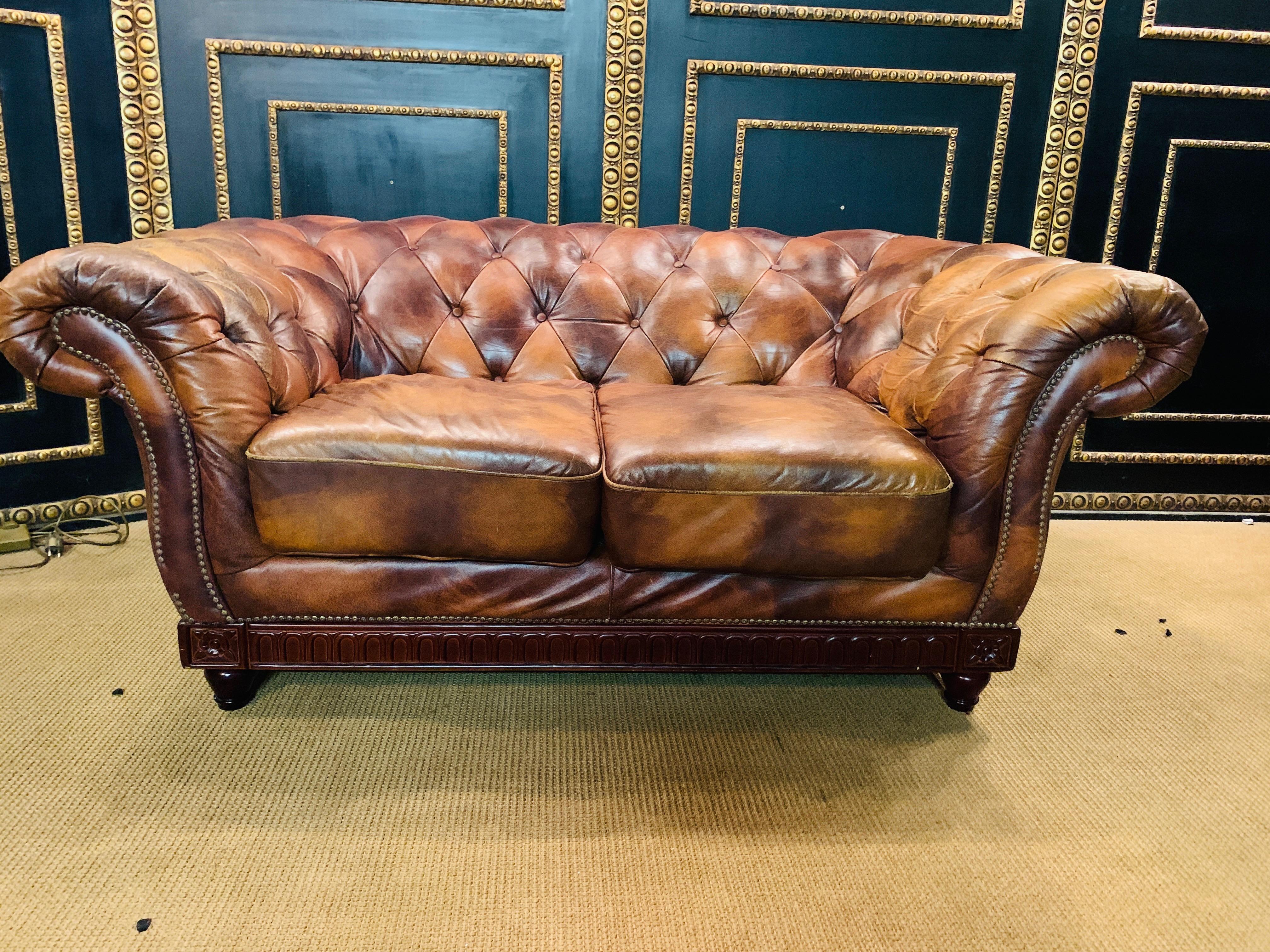 We are delight to be able to offer you this extraordinary and unique Chesterfield 2-seater sofa.
The rare cow-like leather pattern is an eye-catcher and cannot be found again in this way. Solid wood strips with an oval shape and patterns on each