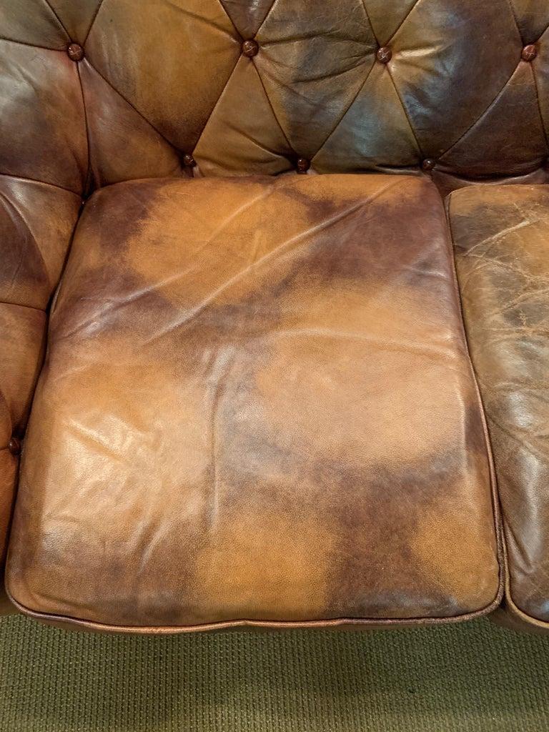 We are delight to be able to offer you this extraordinary and unique Chesterfield 3-seater sofa.
The rare cow-like leather pattern is an eye-catcher and cannot be found again in this way. Solid wood strips with an oval shape and patterns on each