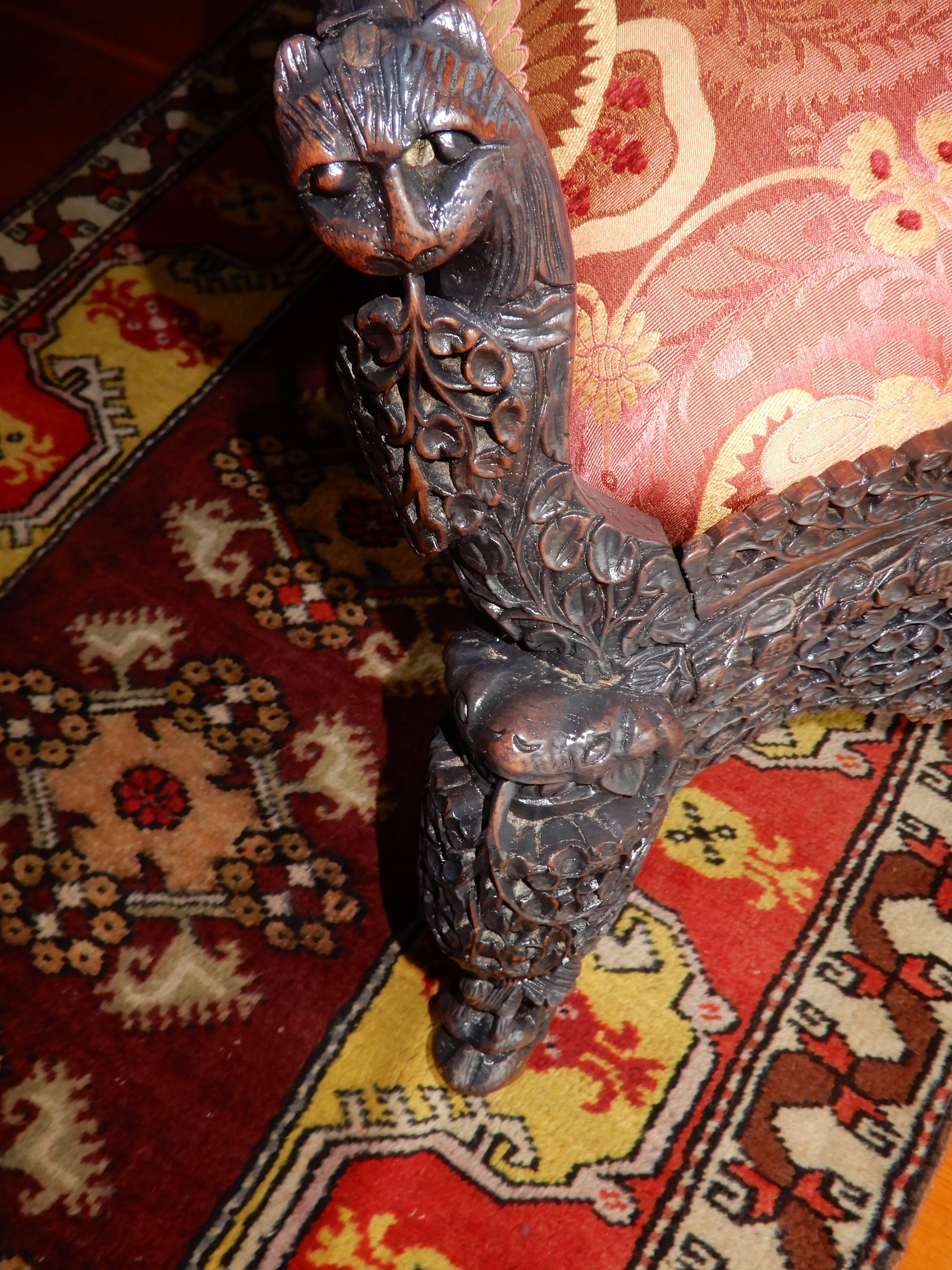 A rare find in this magnificent Anglo-Indian Raj handcrafted child's chair,or slipper chair. Made in Bombay in the late 19th century of solid rosewood, depicting open fretwork, hand-carved animal heads on arms and feet, rolled backrest. New Clarence