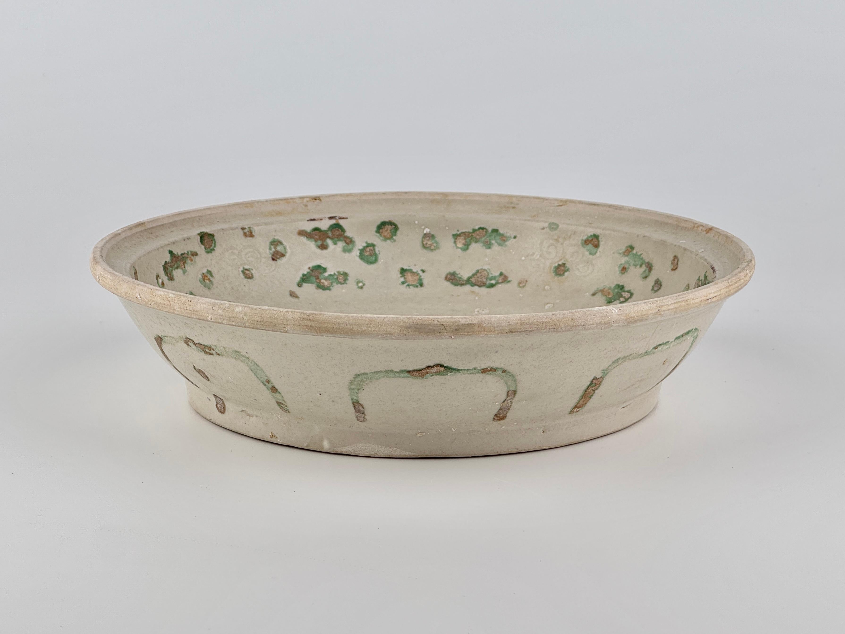A bird on a tree. Stoneware with underglaze blue and painted green. The leaves were creatively expressed with green-glaze. 

The use of green overpainting, a distinctive element in Annamese ceramics, parallels similar examples documented in The Age