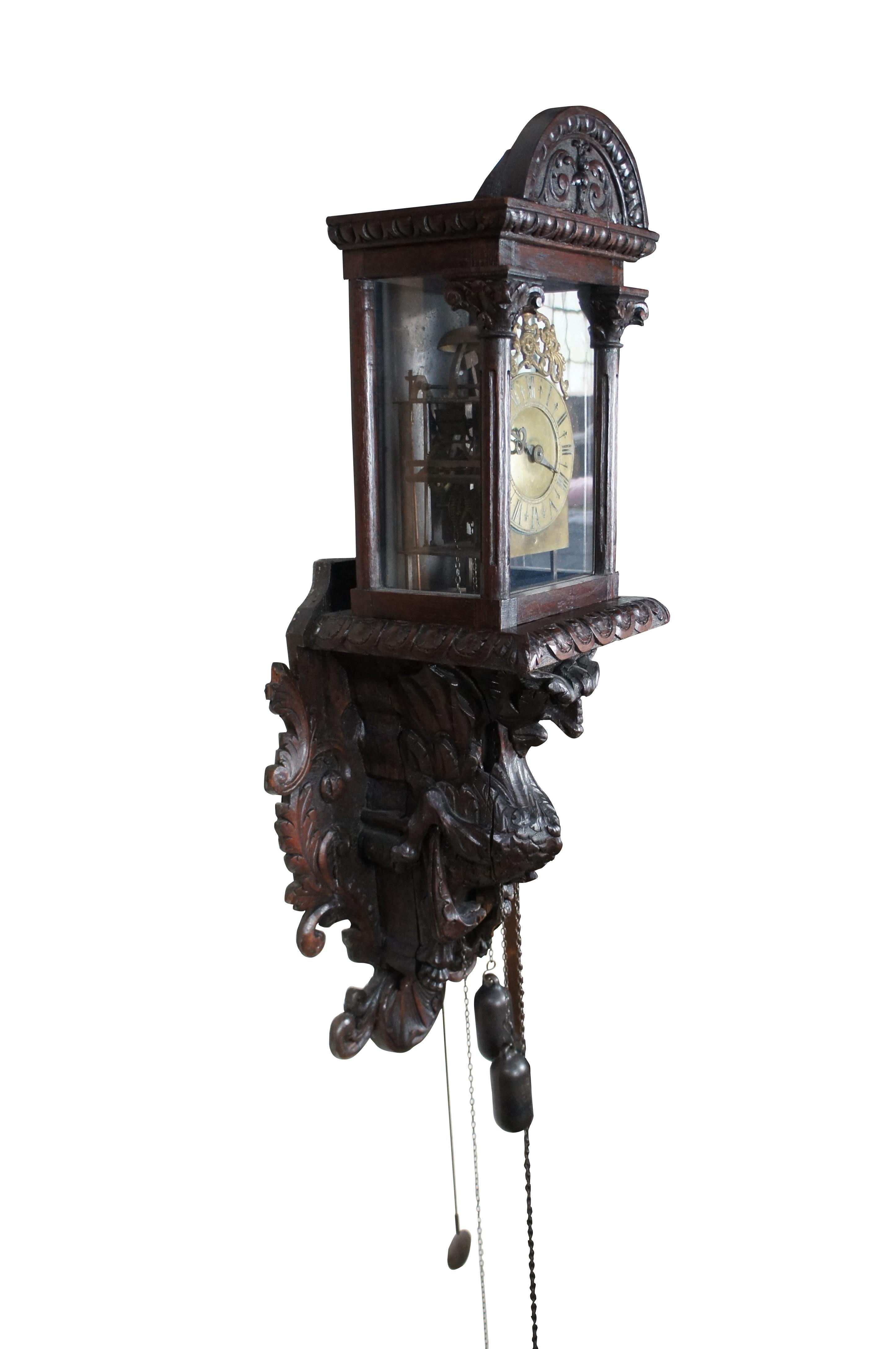 An exceptional hanging lantern clock from the 17th Century. The clock is housed within a hooded glass case with Grecian style carved columns, gadrooning and acanthus scrolled accents. Features a brass face with Roman Numerals, brass hands and a