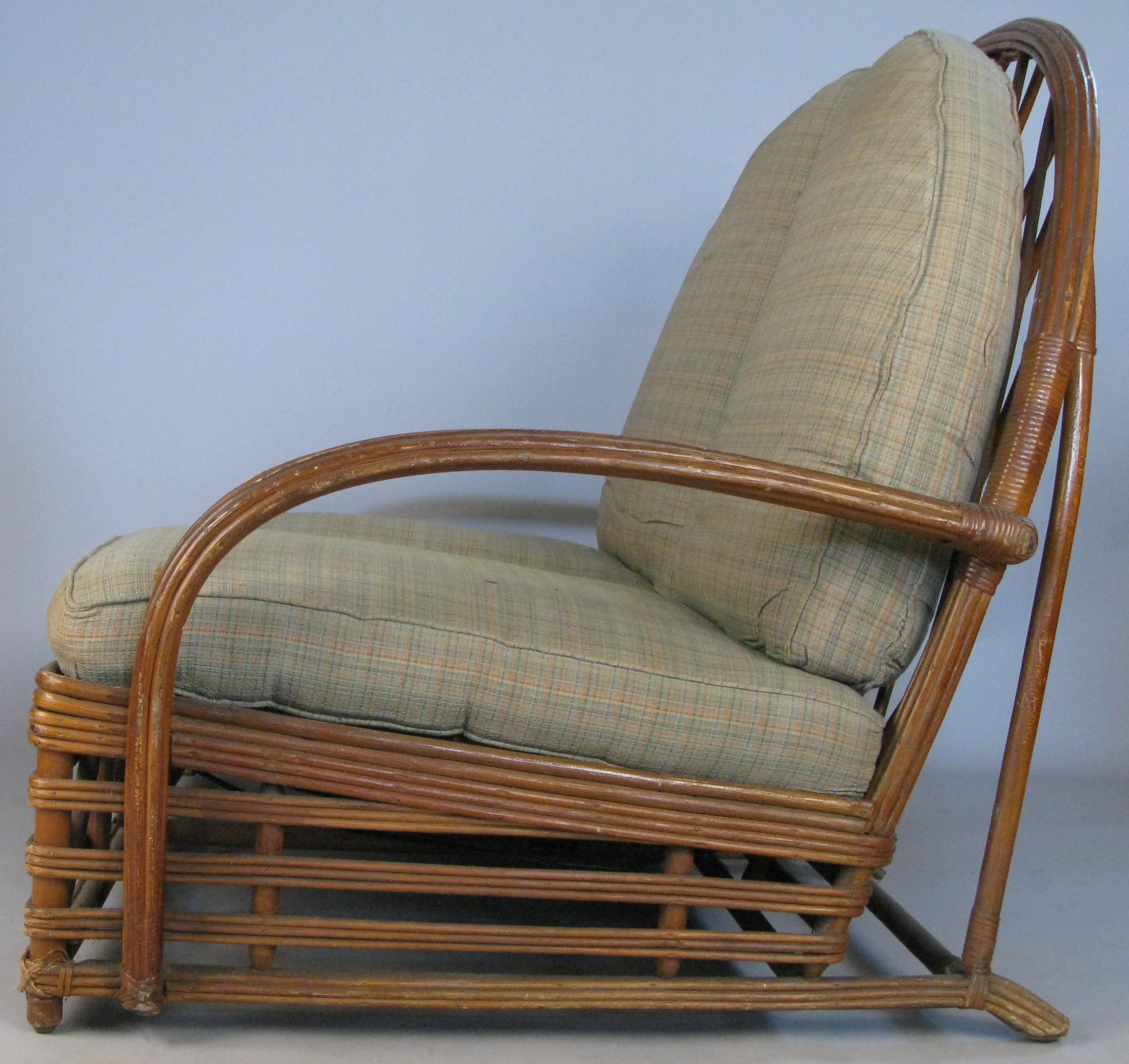 An outstanding antique 1940s rattan settee by Heywood Wakefield. One of their most beautiful designs, with a wide rattan banded base, curved arms, and a stunning tall arch back, with rattan lattice centre. The frame has inset springs, and the