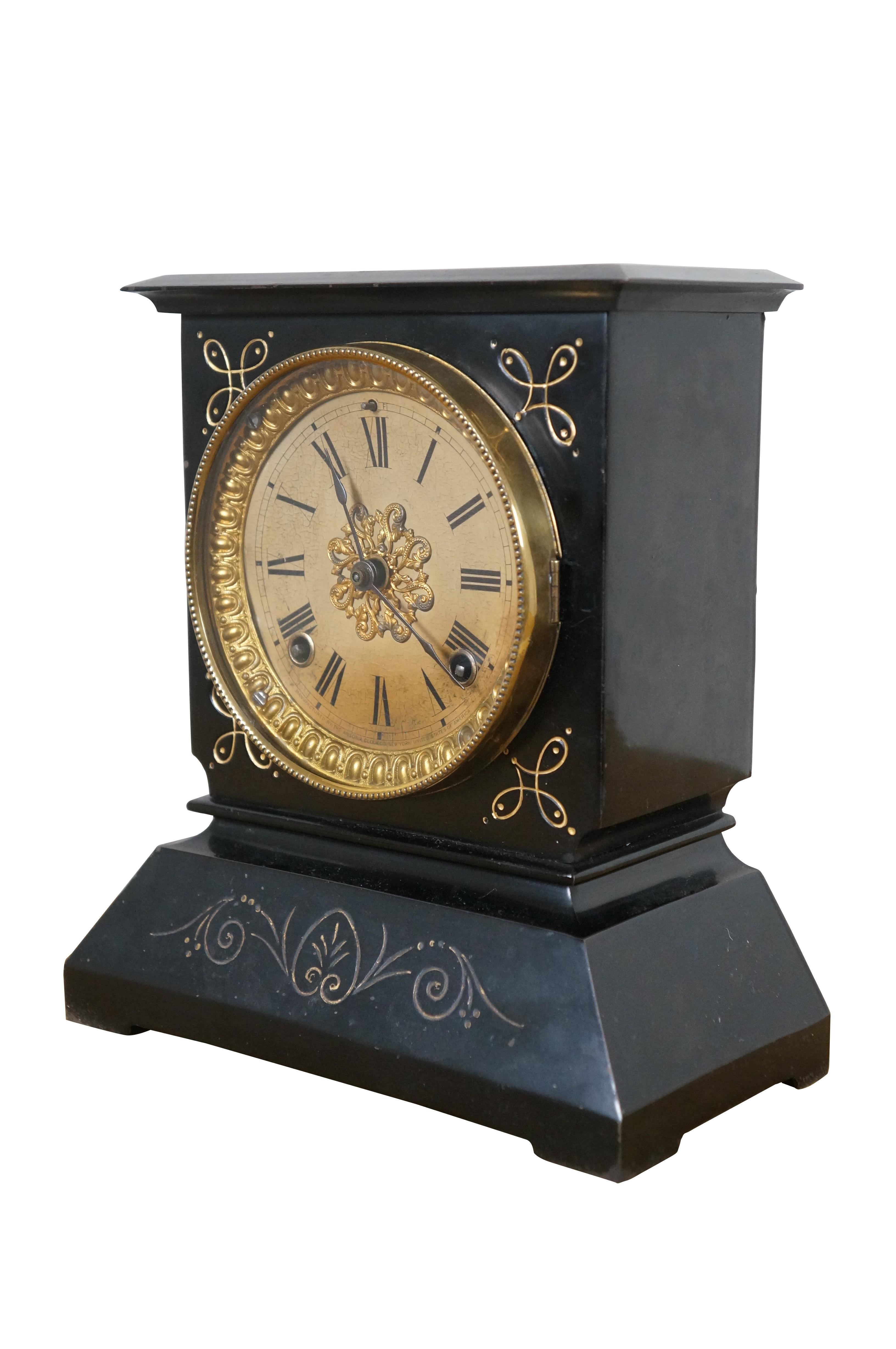 Late 19th century black cast iron Ansonia mantel clock. Black lacquered iron case with gold painted art nouveau foliate details. Key wound, chiming. Off white face with black Roman numerals and hands; gilt floral filigree medallion and egg and dart