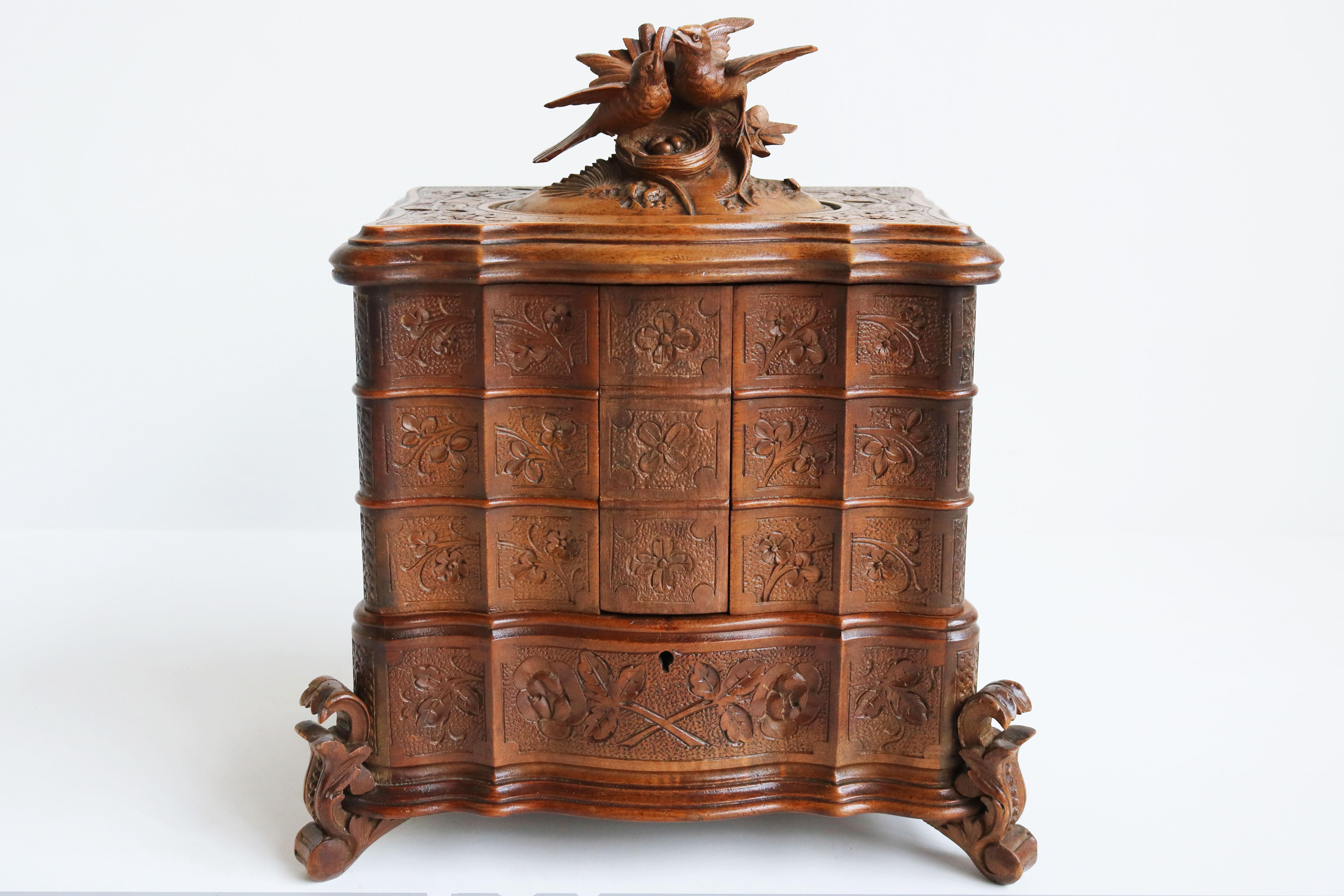 A beautiful, very finely carved antique black forest jewelry box from the late 19th/ early 20th century made in Switzerland. 
A large and impressive four-tiered piece with 6 swing out shelves. Fully hand-carved out of Fruitwood. 
Each part is